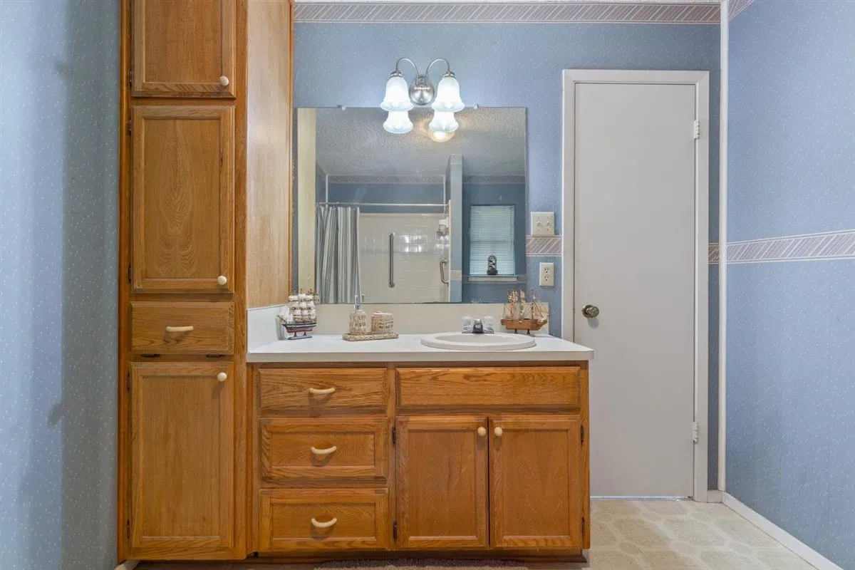 Wood-finish vanity with a white countertop and an integrated sink