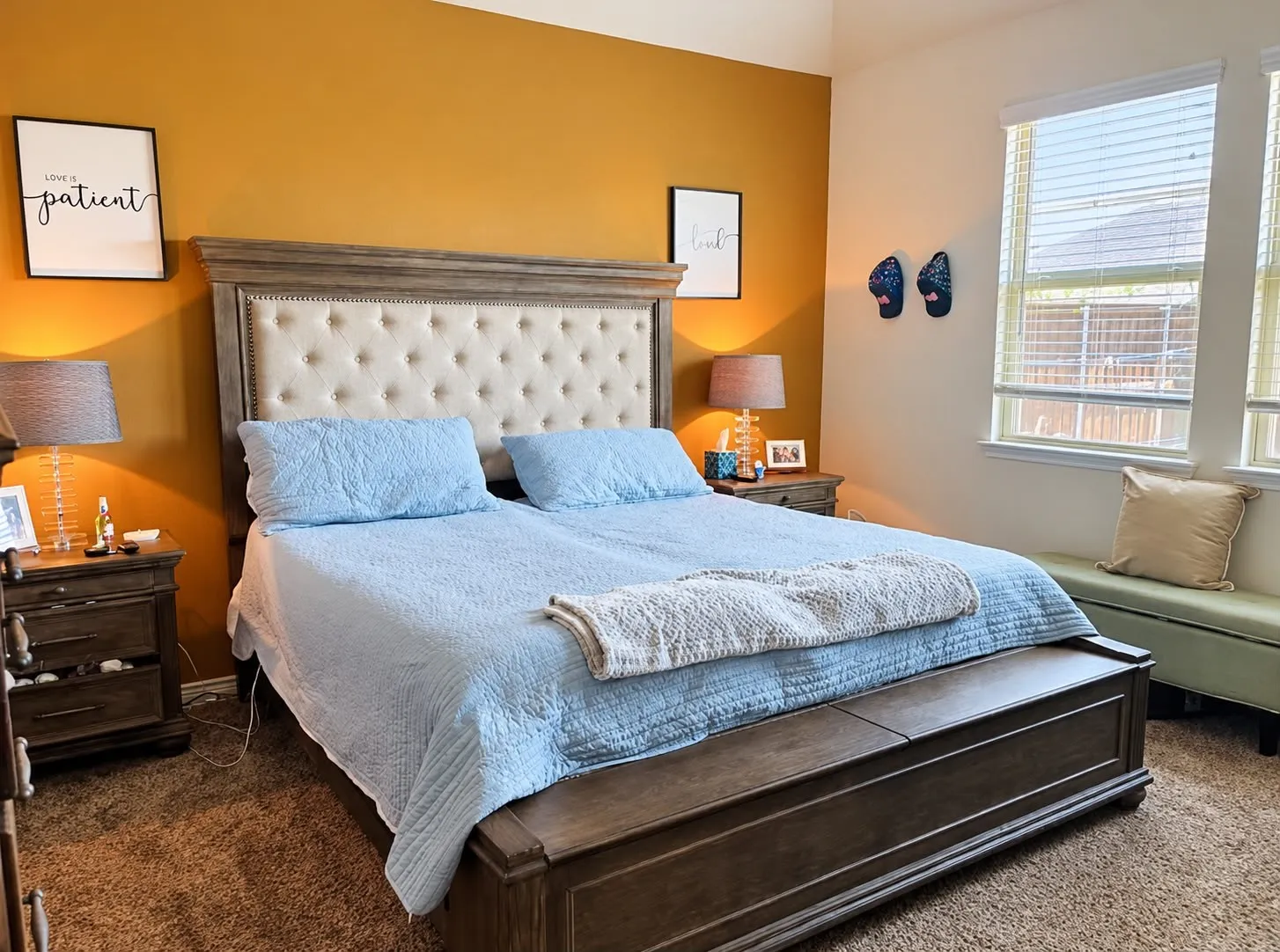 Room featuring an accent wall, two window openings, and wall-to-wall carpeting