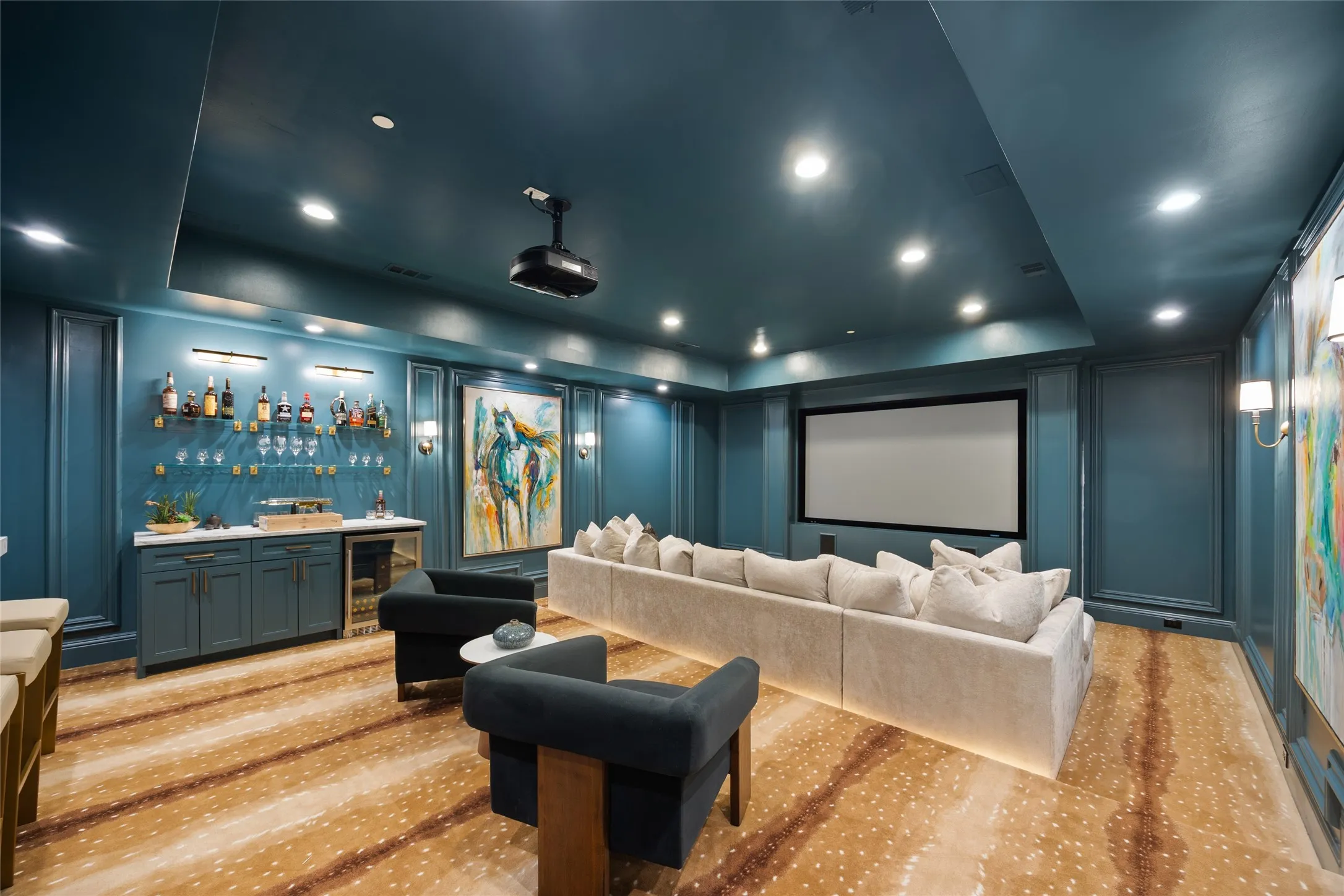 Integrated projection screen, built-in wet bar with cabinetry, recessed ceiling lighting, wall-mounted sconces, and patterned flooring
