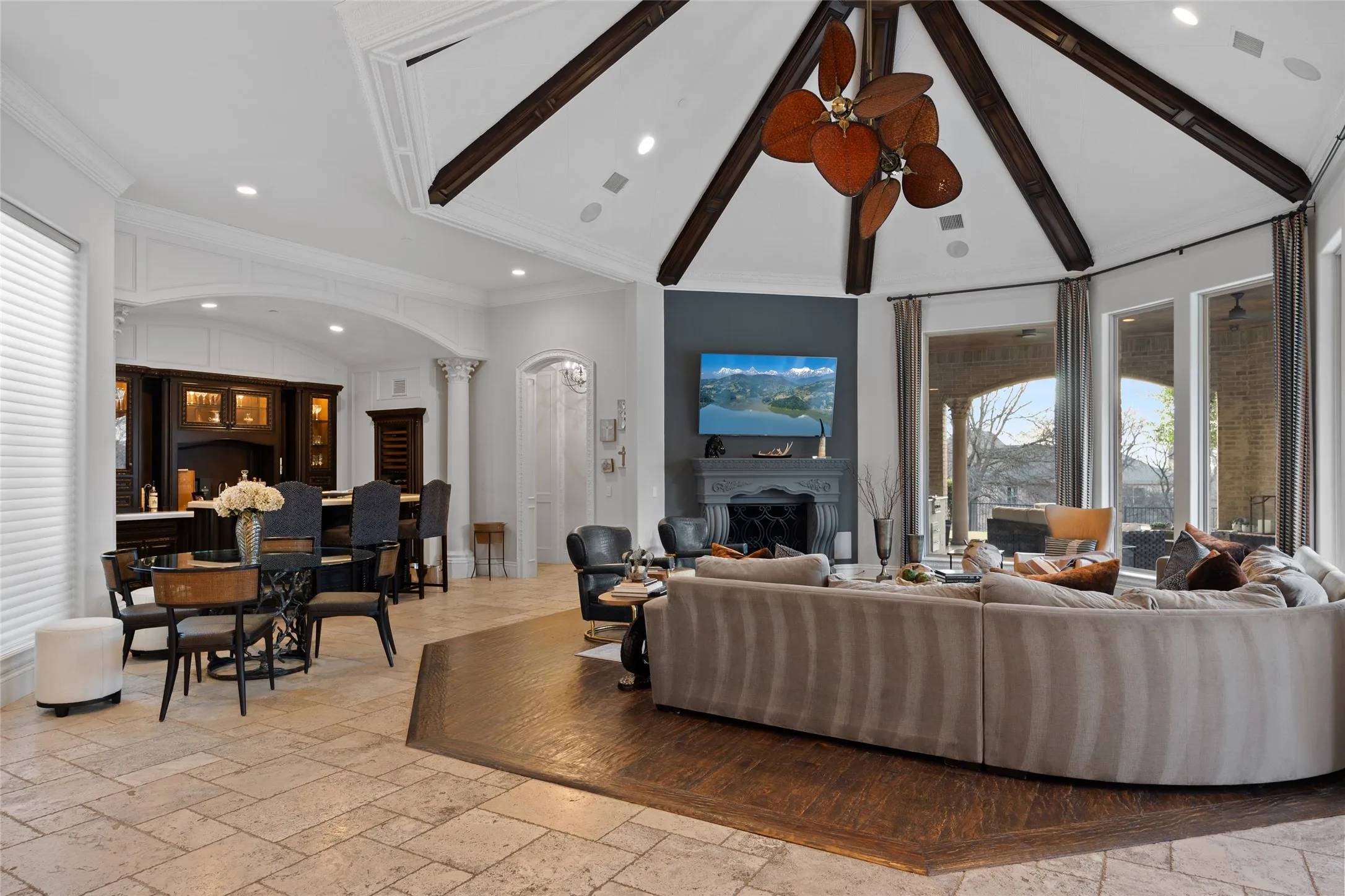 Vaulted ceiling with exposed wood beams and a decorative ceiling fan