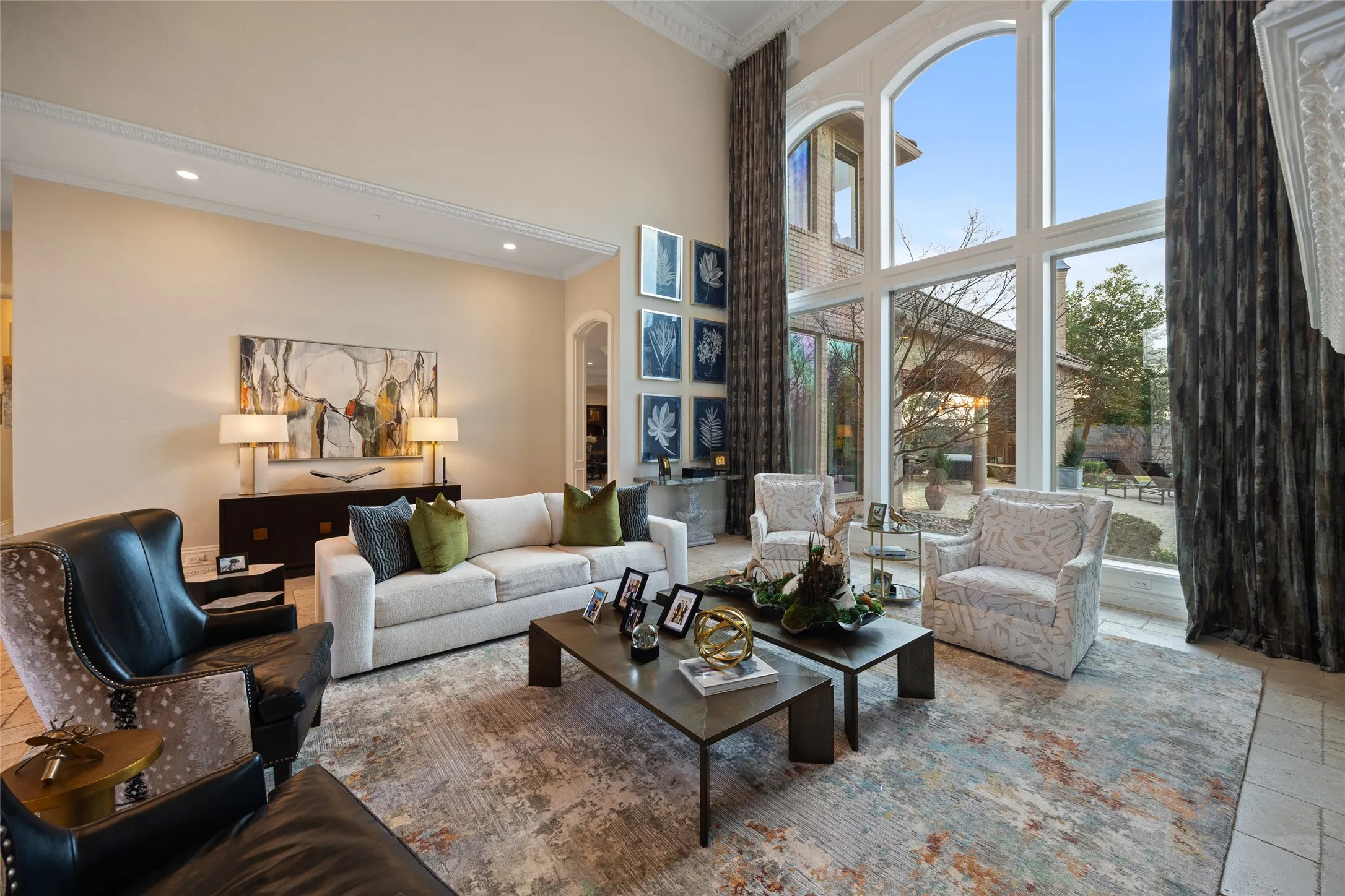High ceilings with crown molding, recessed lighting, and expansive arched windows