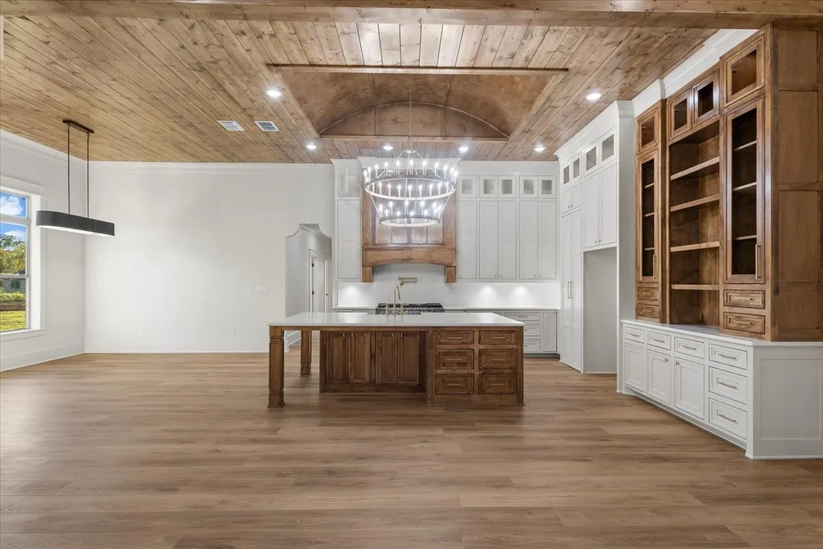 Wood-finish flooring throughout, featuring a kitchen island with storage and a light-toned countertop