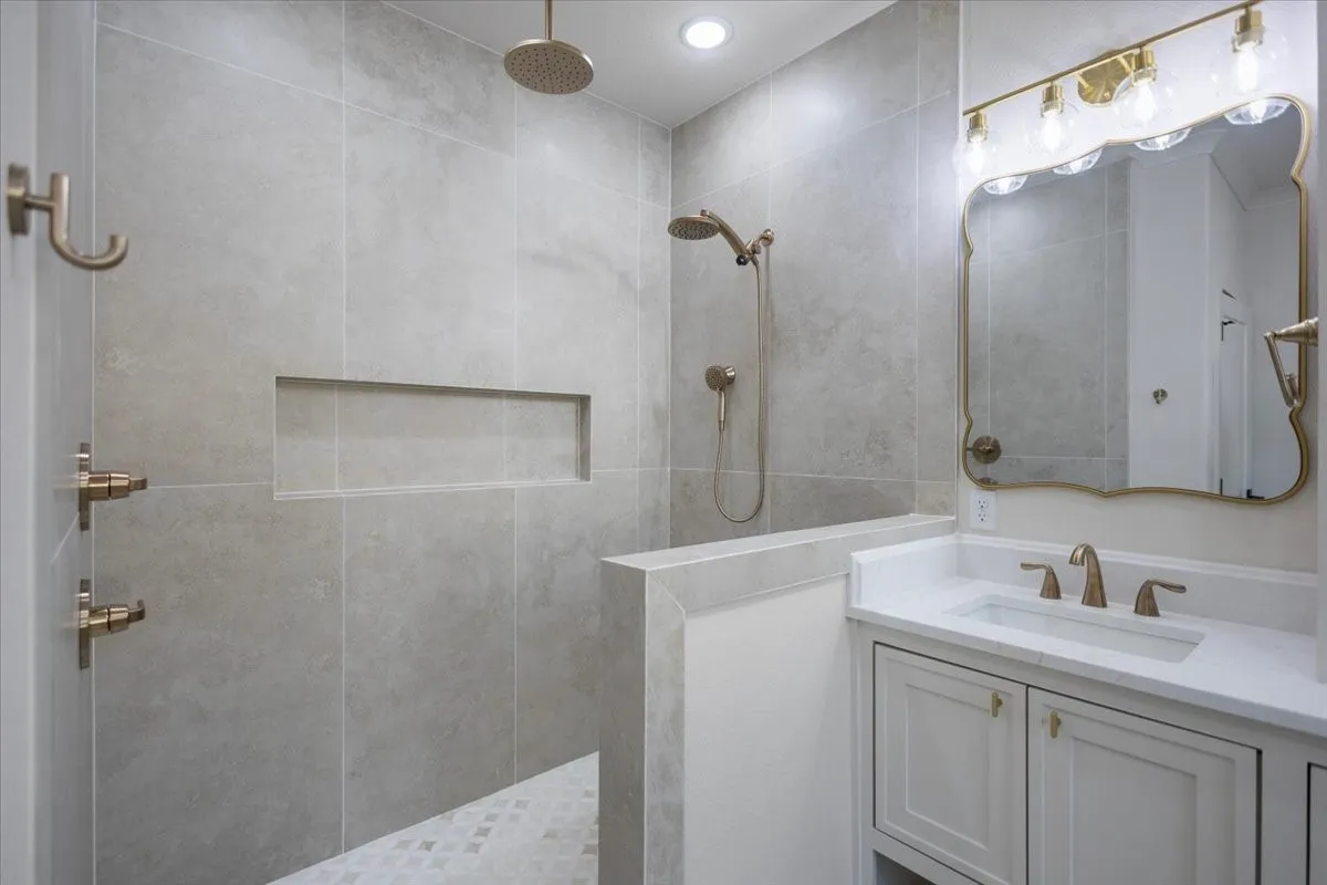 Walk-in shower with a rain shower head, handheld shower, and recessed niche