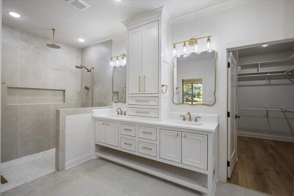 Dual vanity with white cabinetry and gold-toned hardware