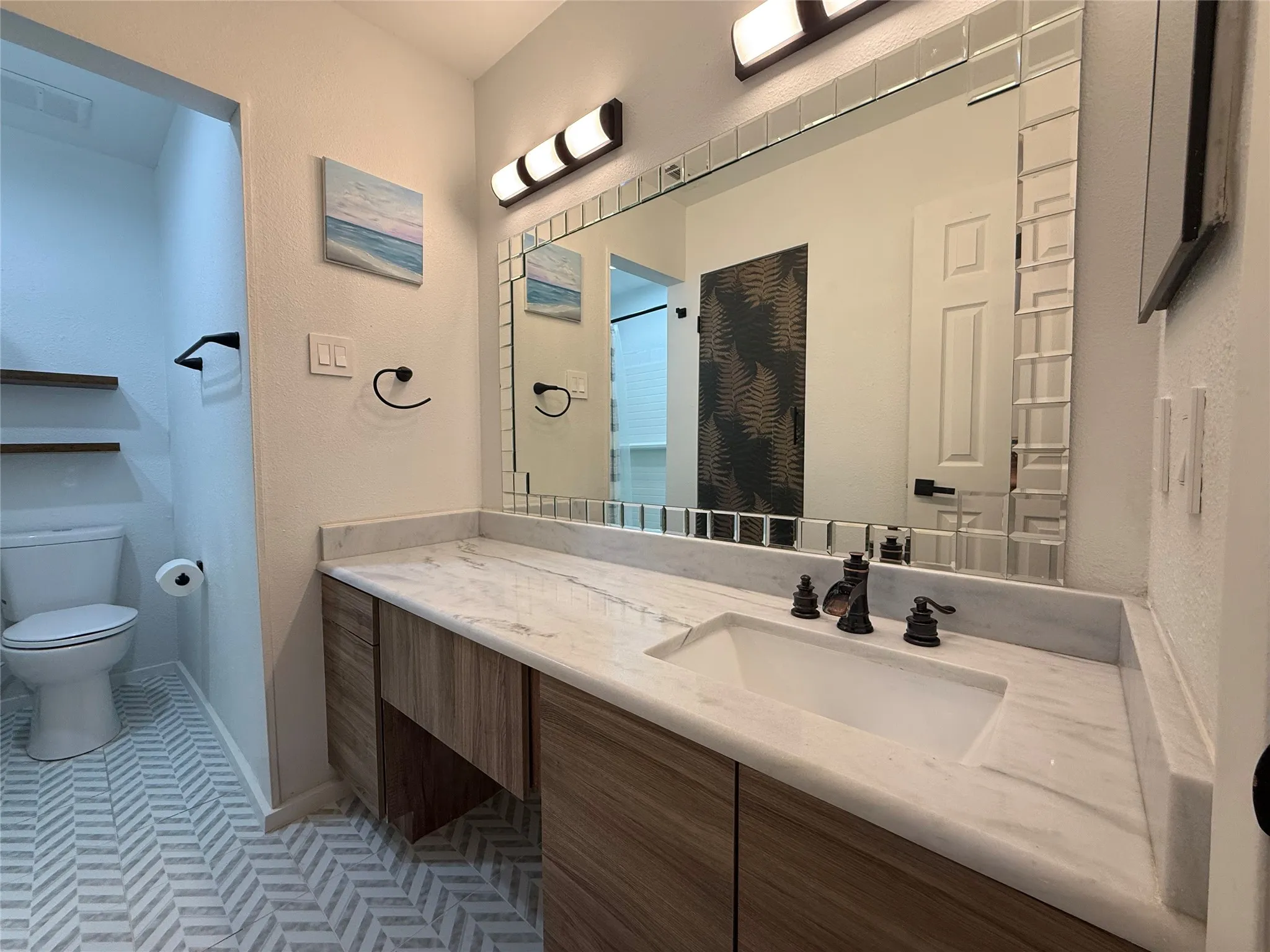 Vanity with integrated sink, wood-finish cabinetry, and a light-toned countertop