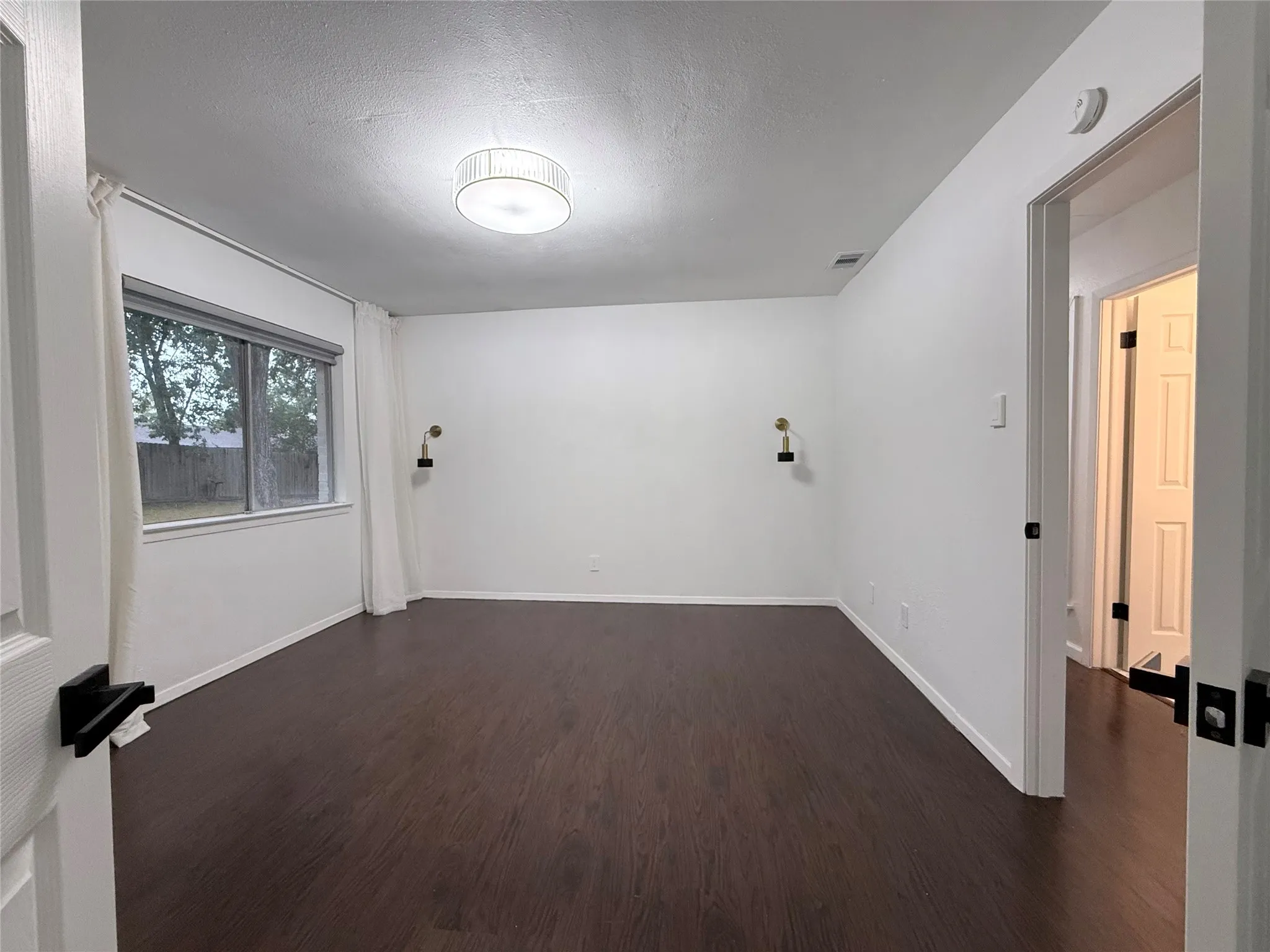 Dark wood-finish flooring with white walls and trim