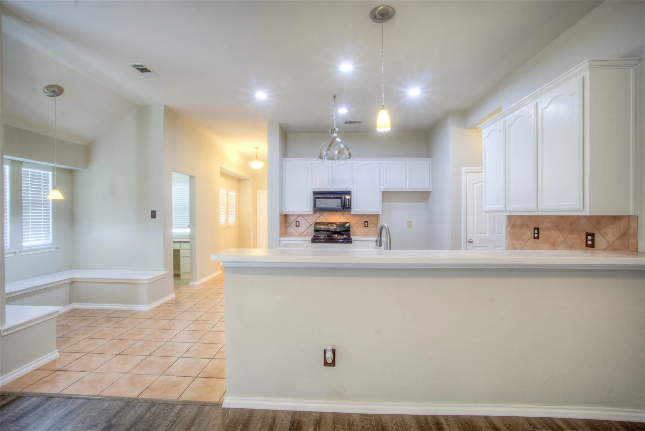 Kitchen featuring white cabinetry, a built-in microwave, and a stainless steel sink