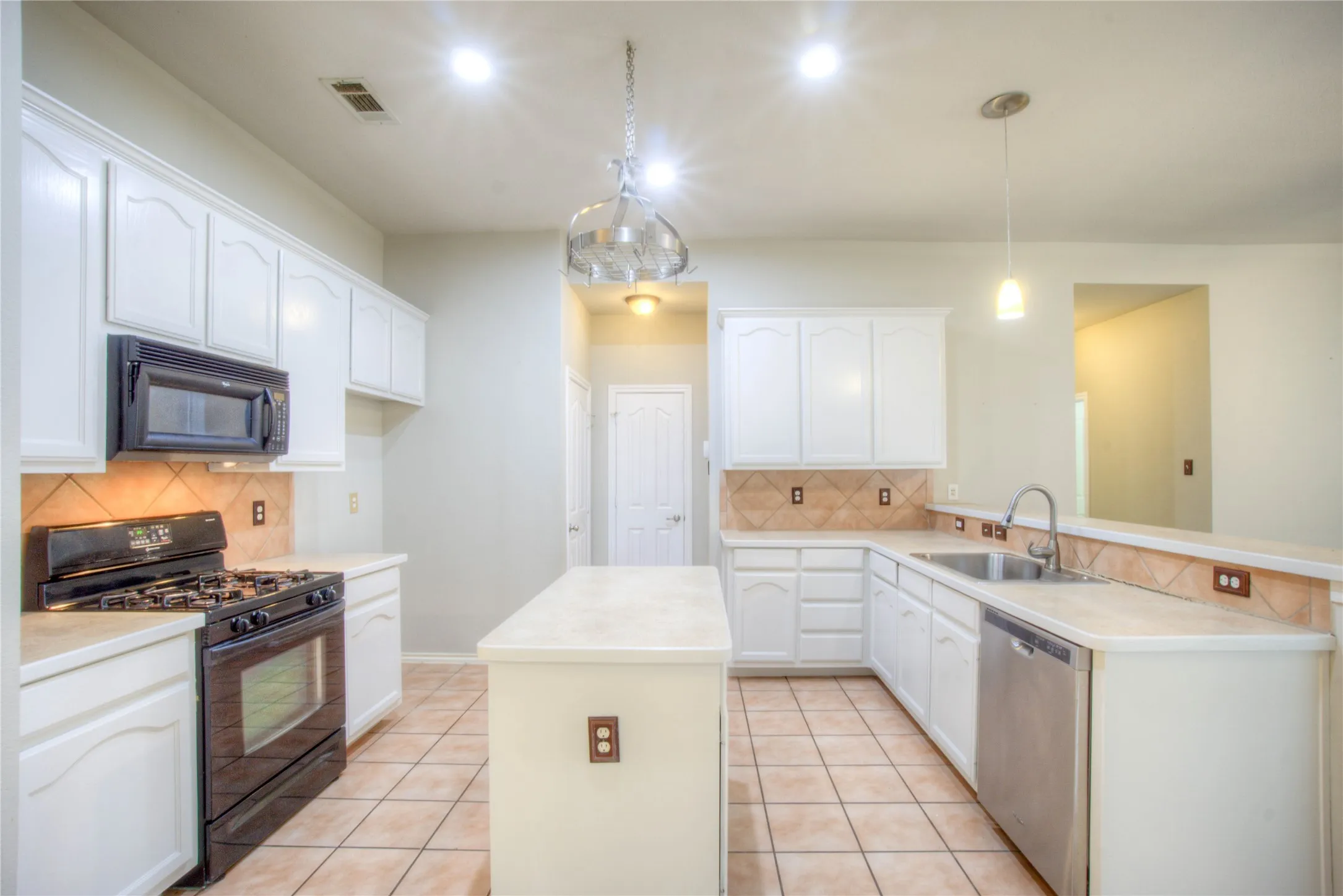 Kitchen featuring white cabinetry, tile flooring, a built-in microwave, a gas range, and a stainless steel dishwasher