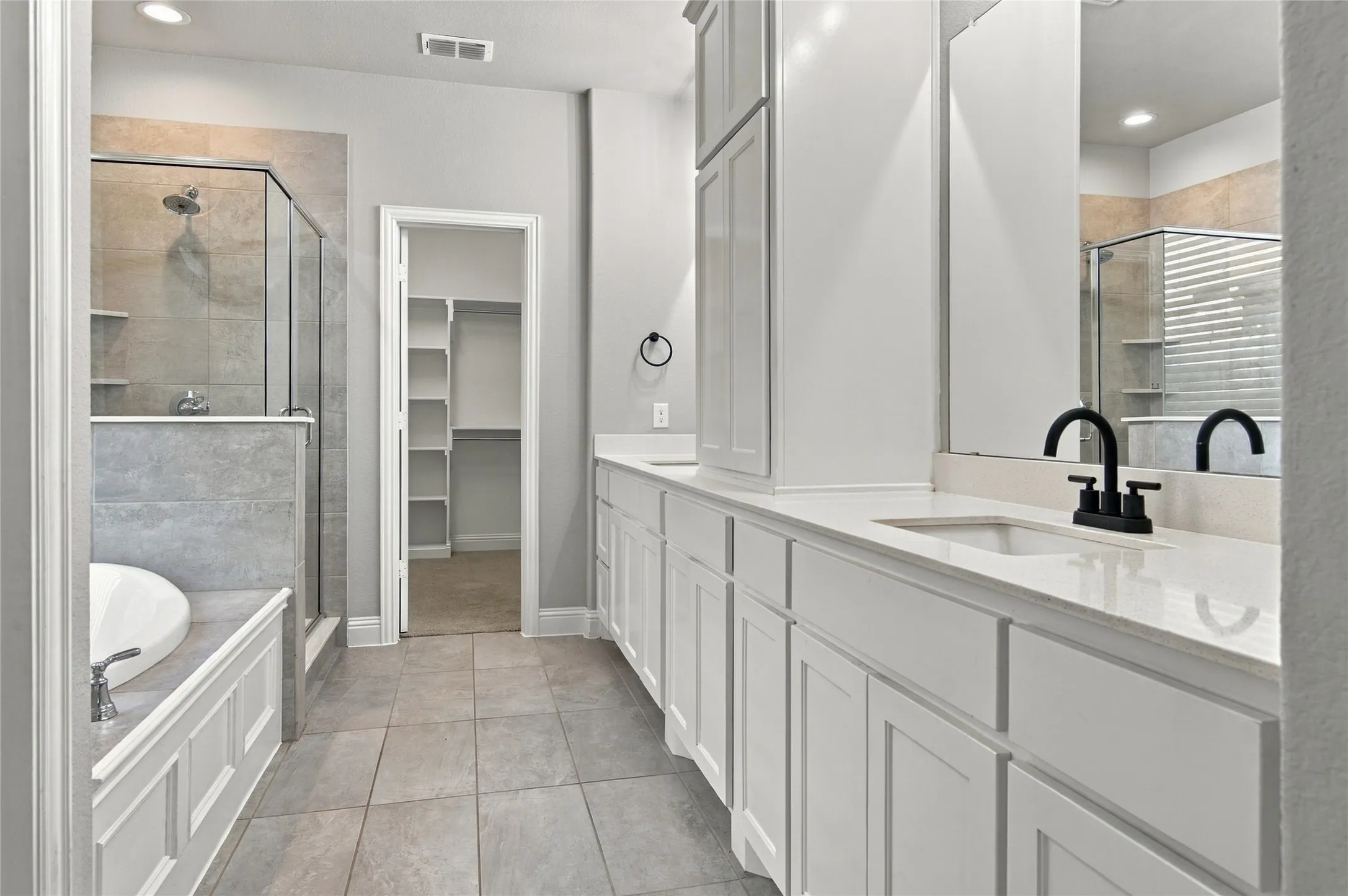 Large Master Bathroom with lots of cabinets, stone countertops, dual vanities