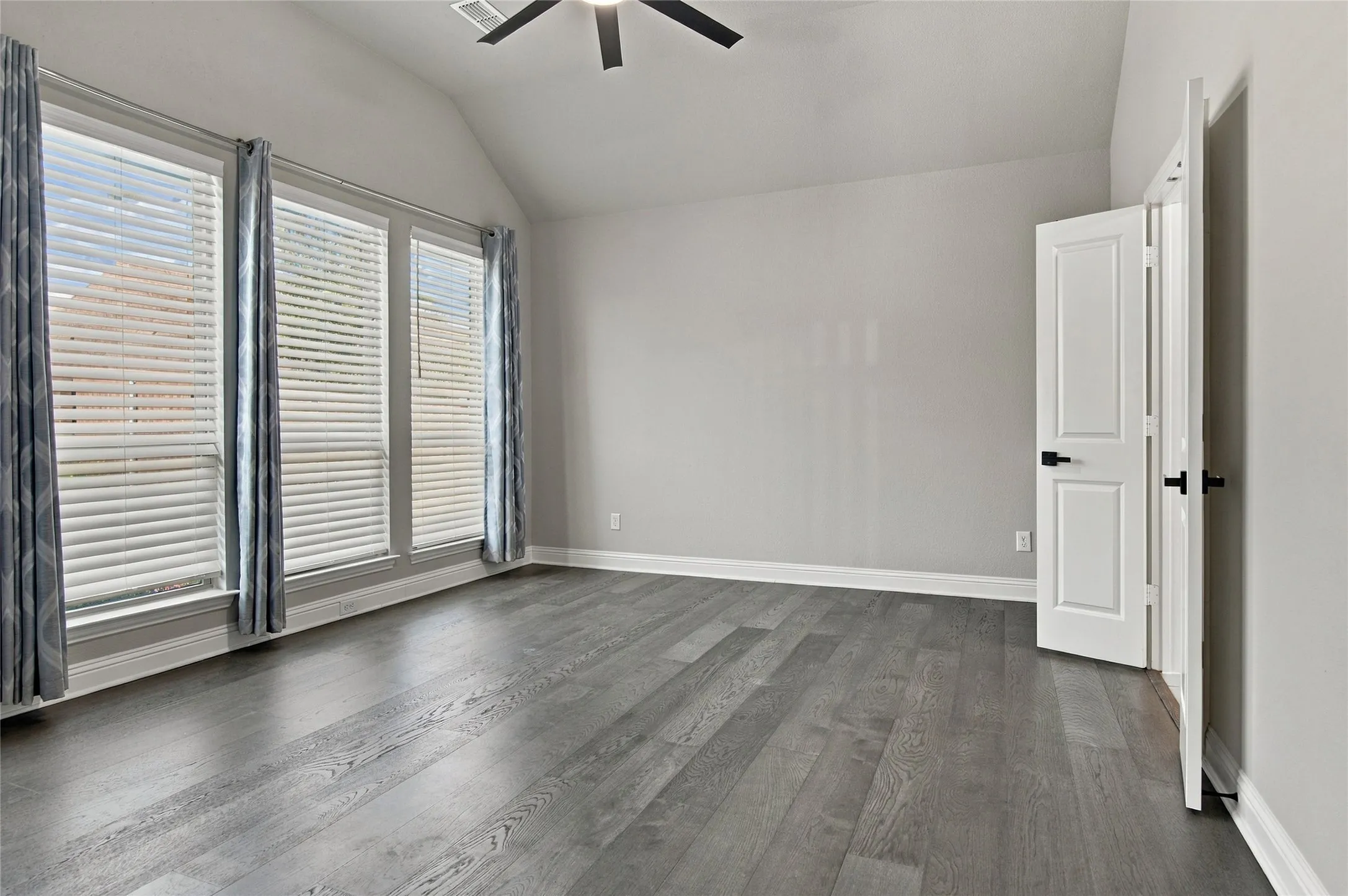 Large Master Bedroom with hardwood floors and vaulted ceilings