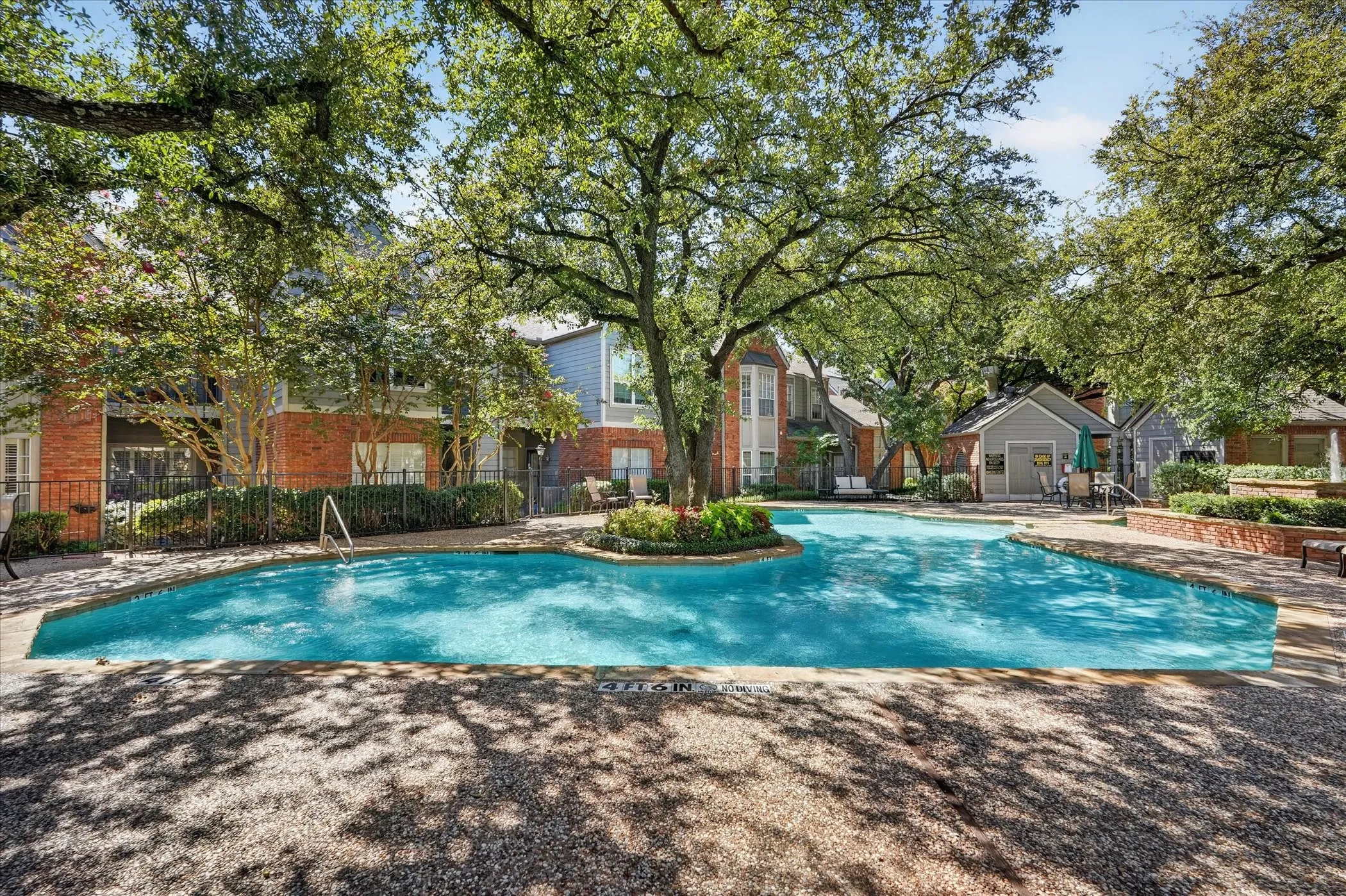 Swimming pool with integrated landscaping and surrounding aggregate surface