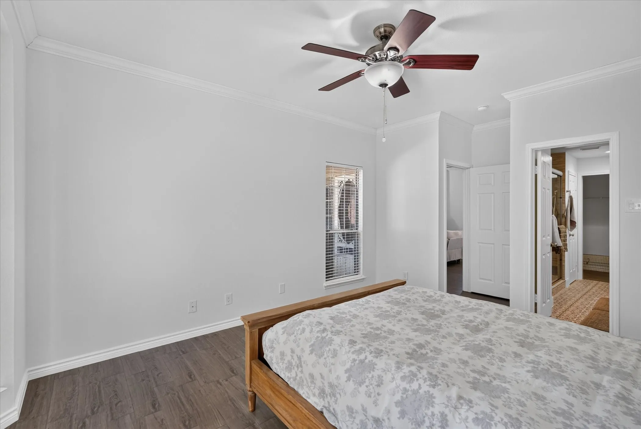 Crown molding, wood-finish flooring, ceiling fan with integrated lighting, and window with blinds