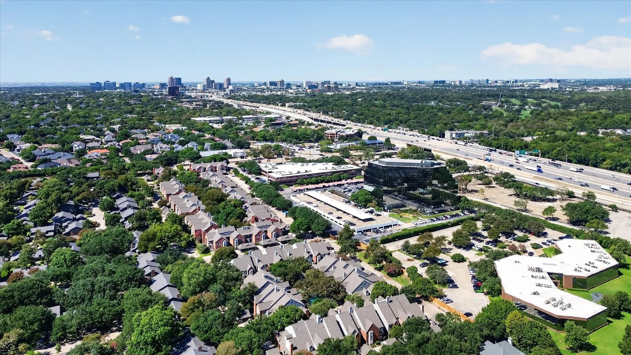 Expansive urban landscape featuring a cityscape, highway infrastructure, and various commercial structures