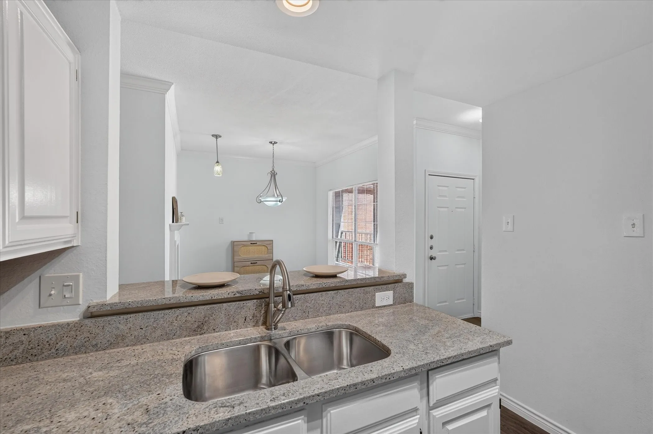 Kitchen featuring granite countertops, a stainless steel double-basin sink, white cabinetry, and recessed lighting