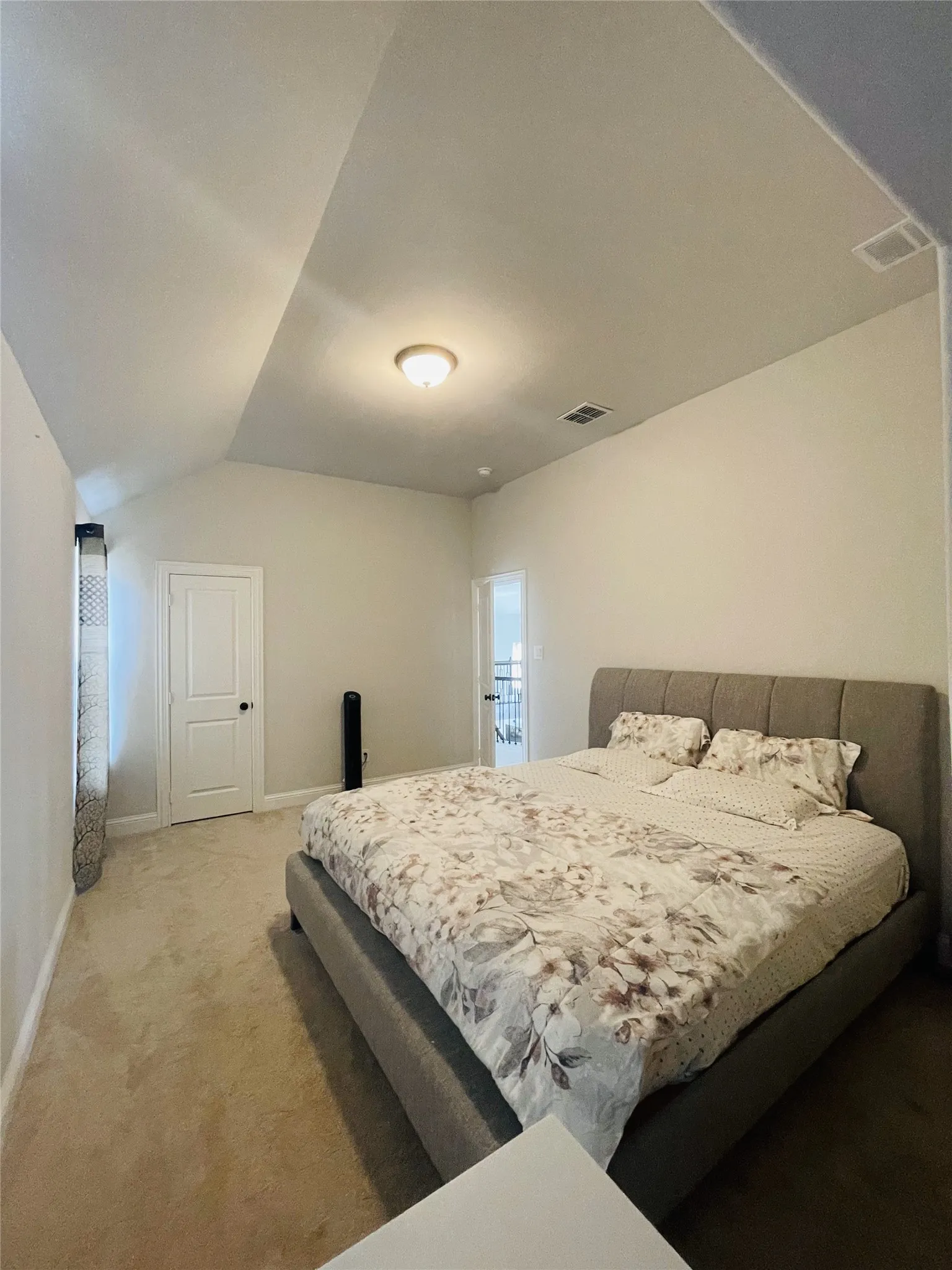 Carpeted bedroom with lofted ceiling