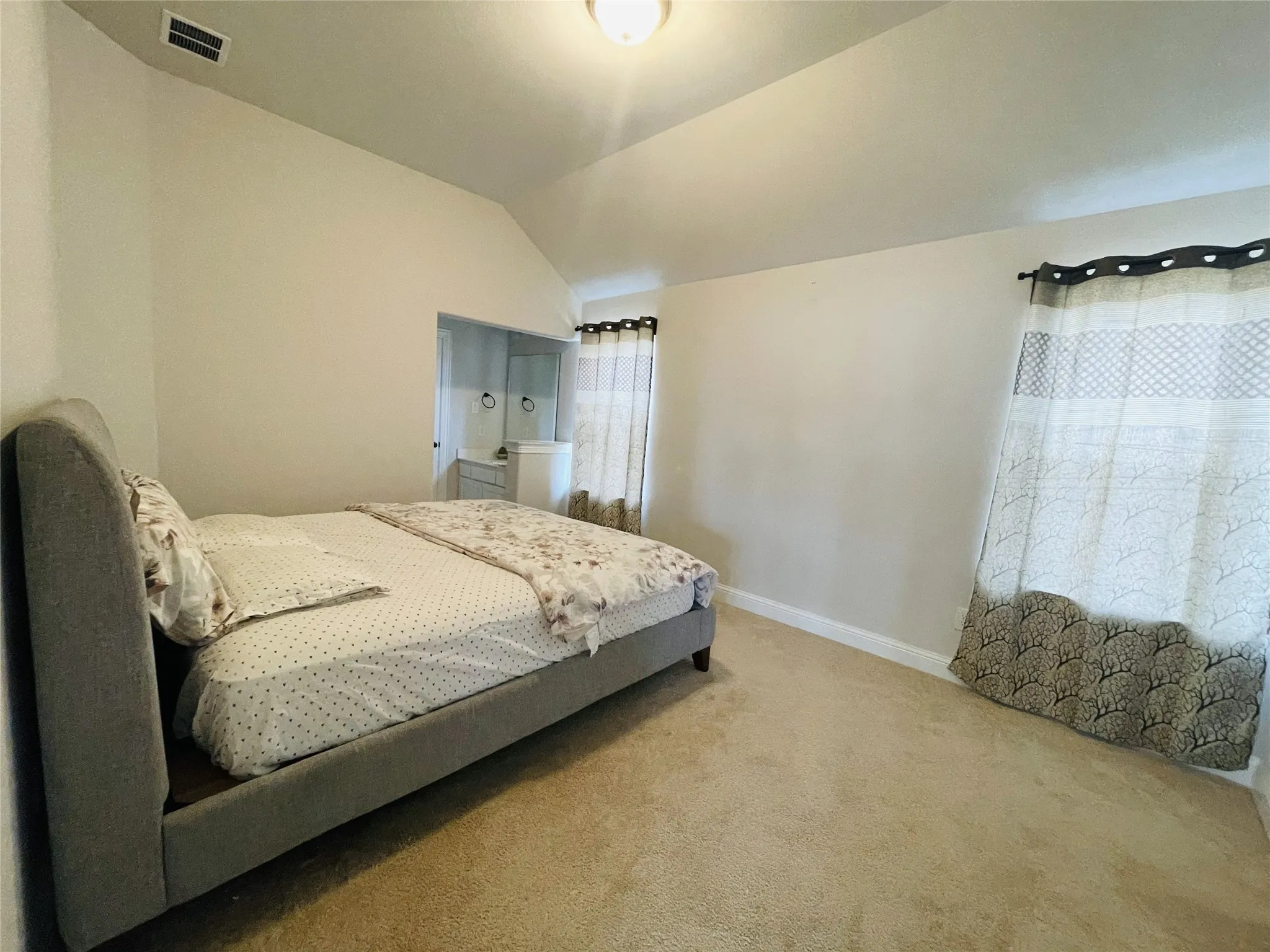 Carpeted bedroom with lofted ceiling