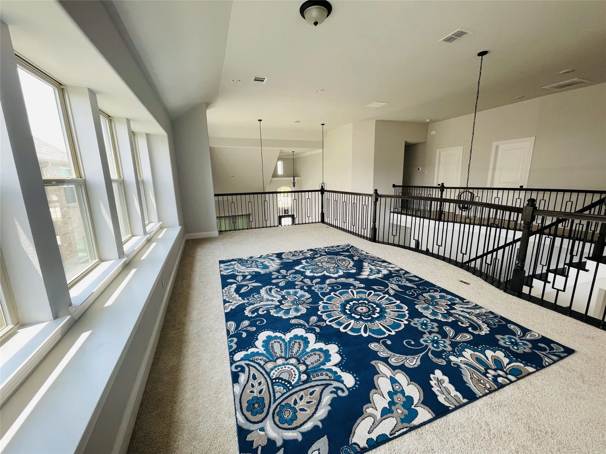 Hallway with carpet, a chandelier, and plenty of natural light