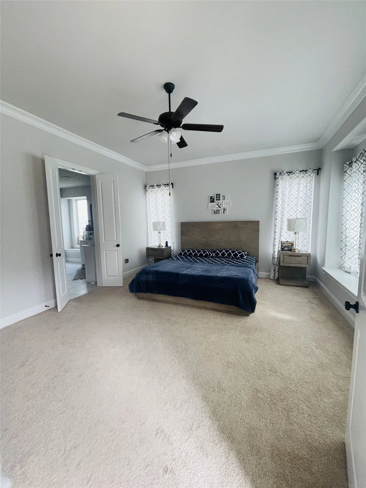 Unfurnished bedroom with ceiling fan, carpet floors, and crown molding