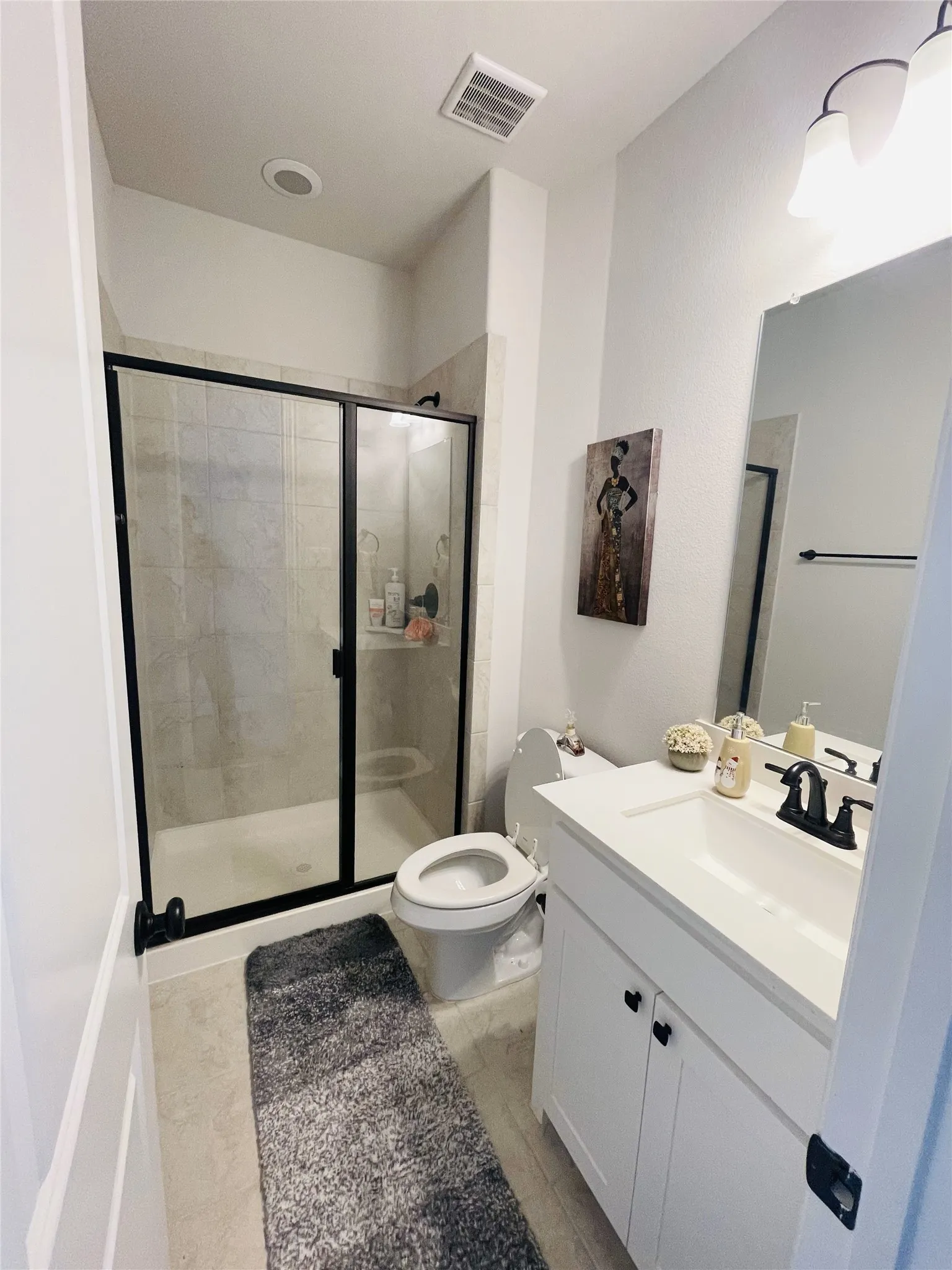 Bathroom with toilet, vanity, and walk in shower