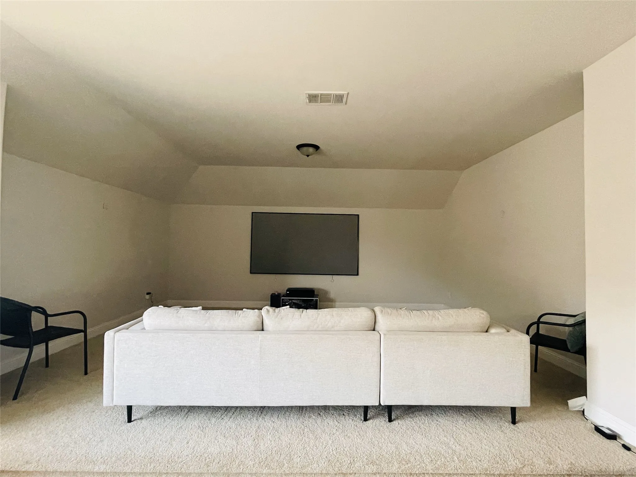 Living room featuring light carpet and vaulted ceiling