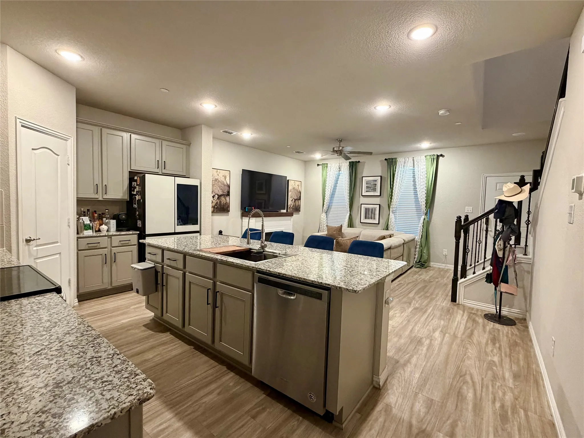 Kitchen island with integrated sink, stainless steel dishwasher, and granite countertops