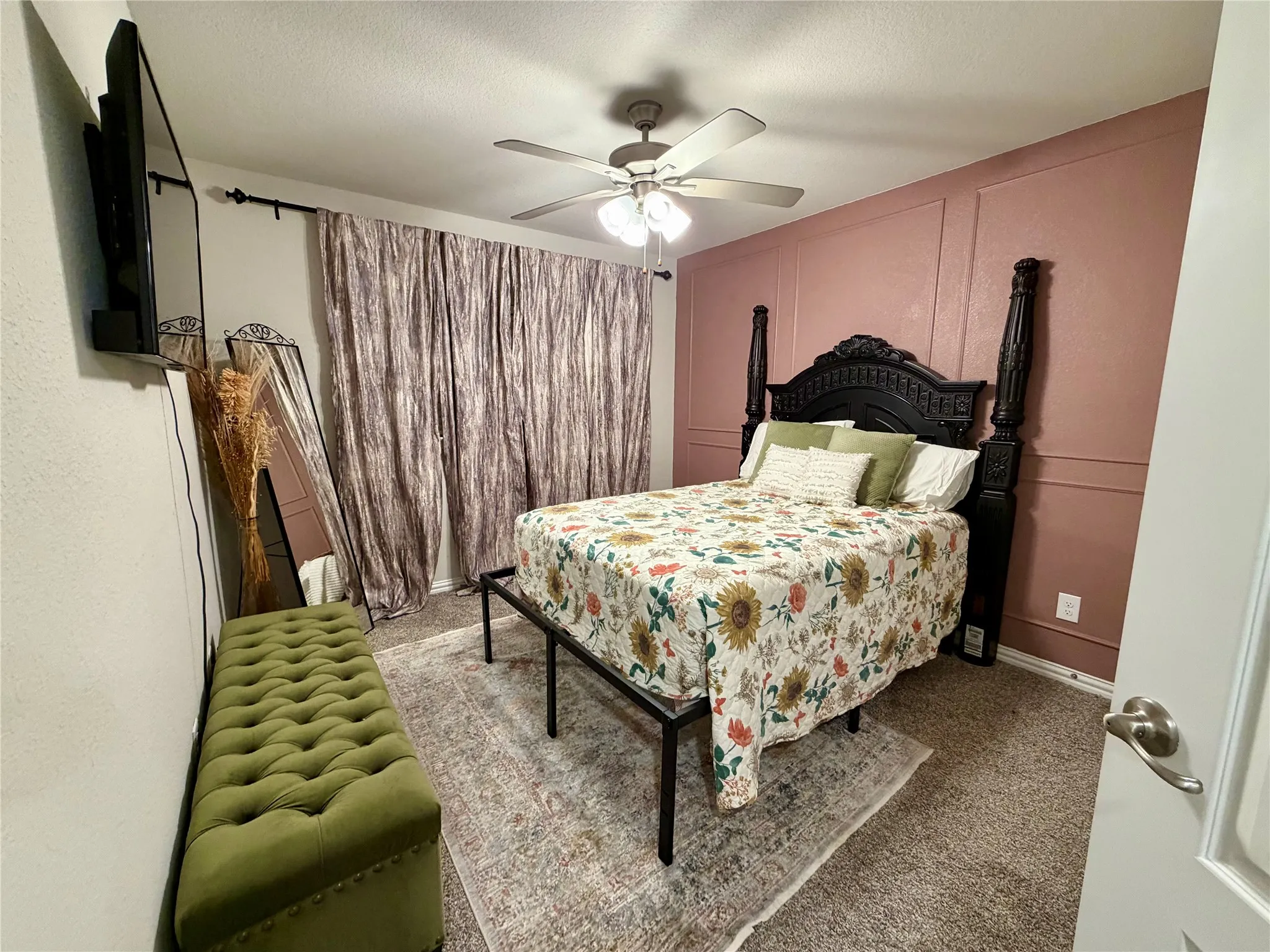 Recessed wall paneling, ceiling fan with integrated lighting, wall-mounted television, and neutral carpet flooring