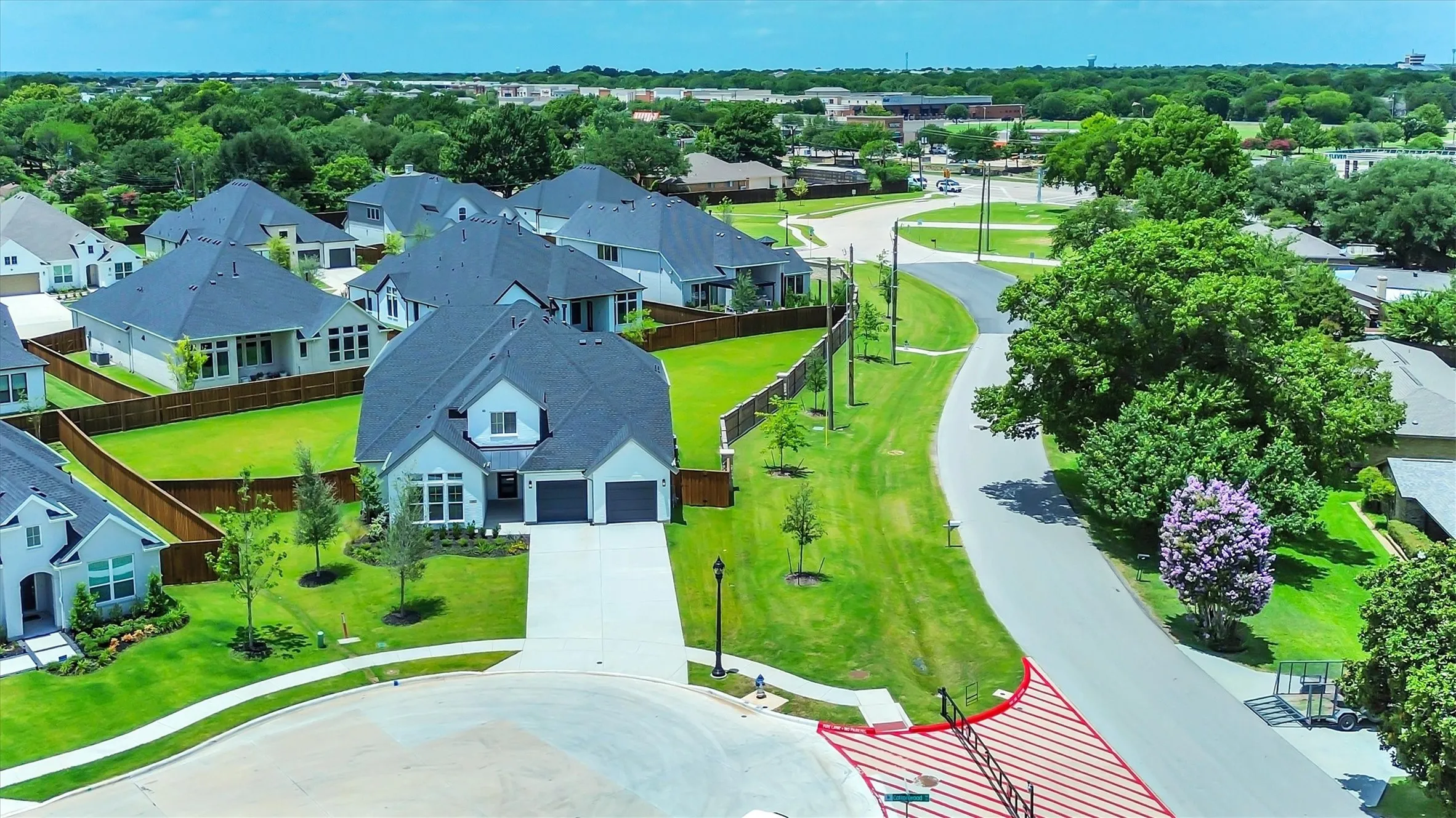 Contemporary residence with an attached two-car garage, concrete driveway, and established landscaping