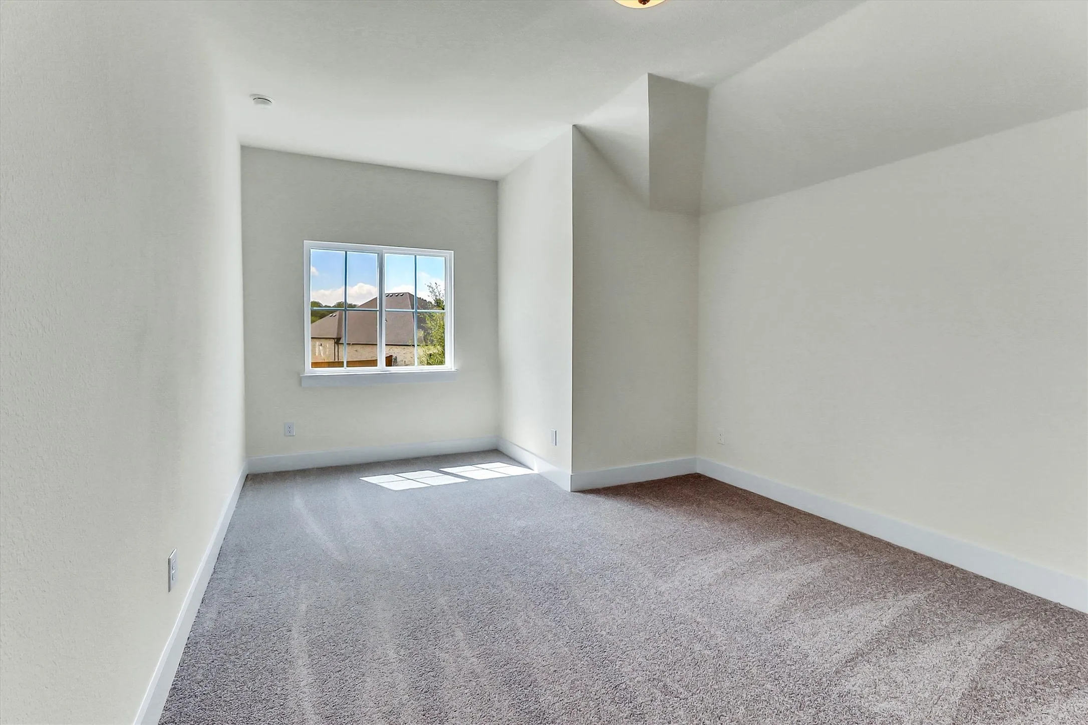 Neutral-toned wall finish, framed window, textured carpeting, and white baseboards