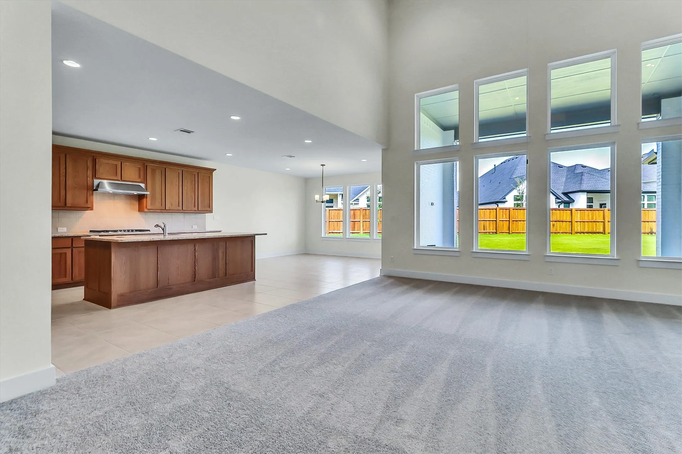 Open-concept living area with high ceilings, recessed lighting, and expansive windows