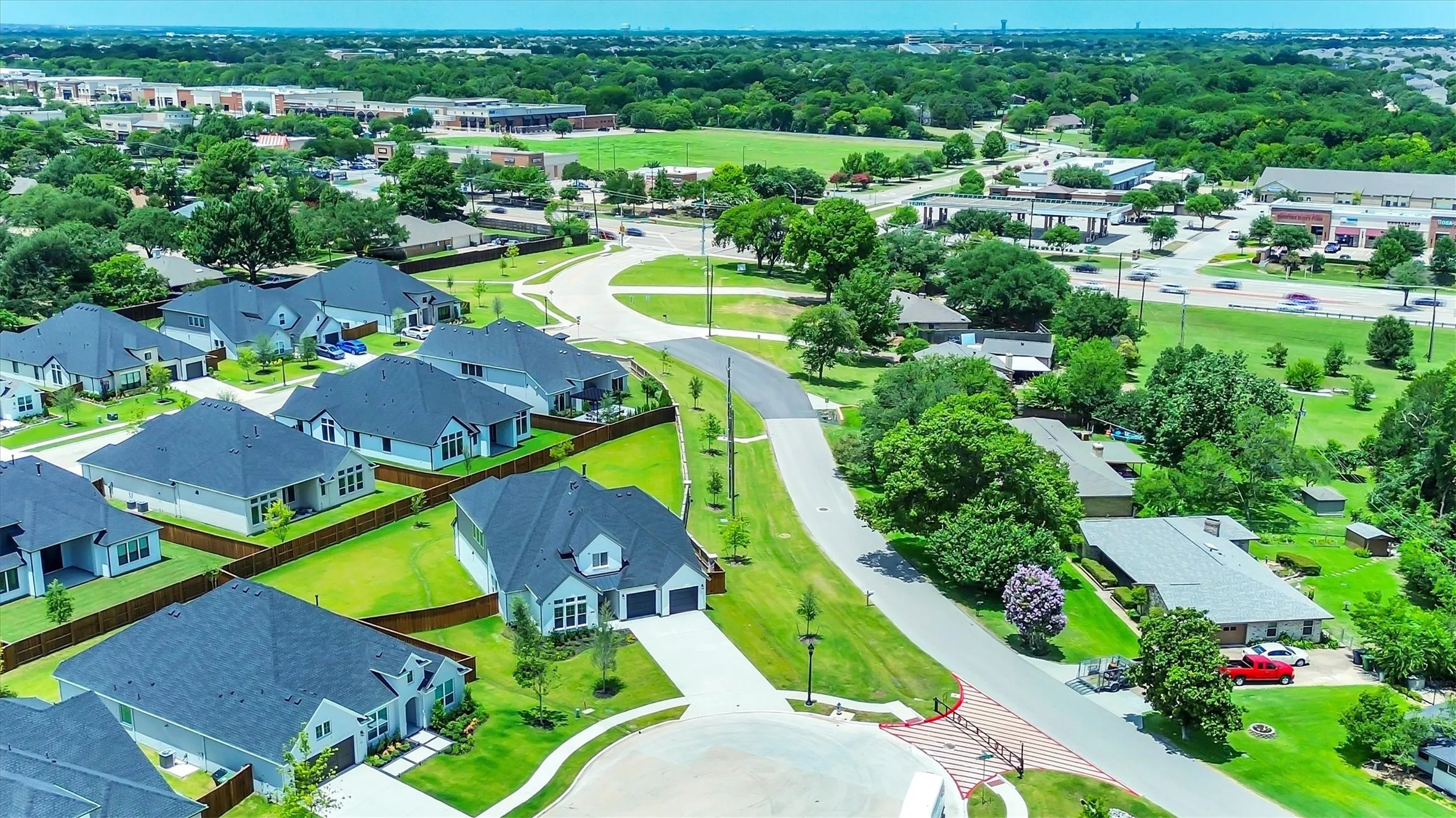 Residential development featuring modern single-family homes with dark roofs and light-colored exteriors