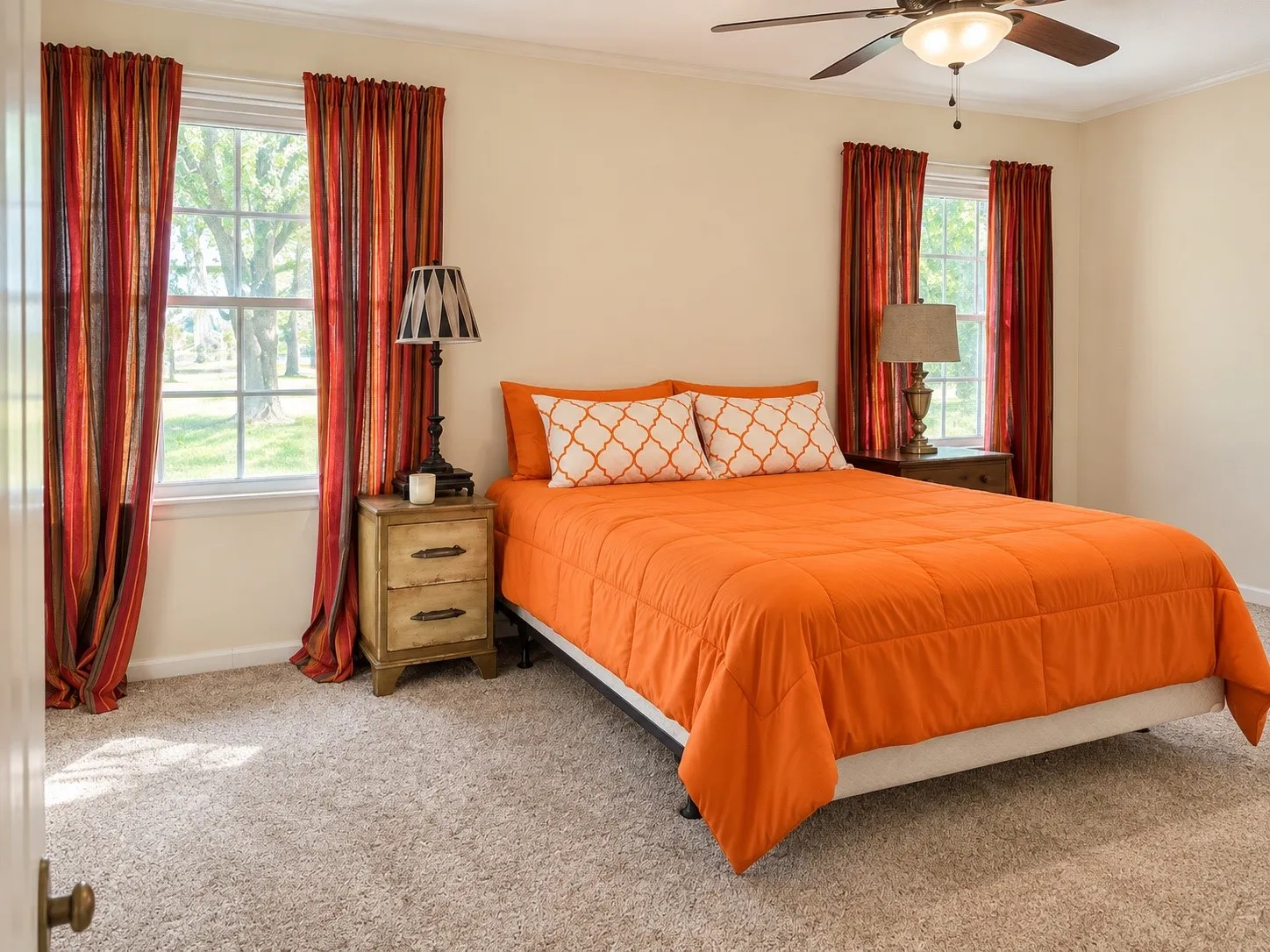 Dual pane windows, ceiling fan with integrated lighting, two side tables with drawer storage, and light-toned carpeting