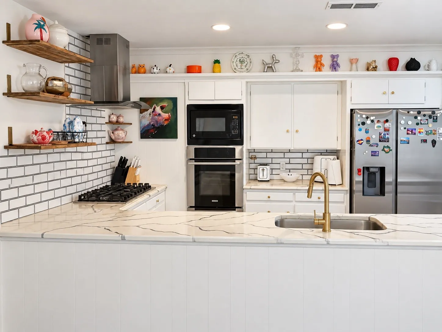 Kitchen featuring a built-in oven, microwave, and refrigerator, brass-finish faucet, and subway tile backsplash