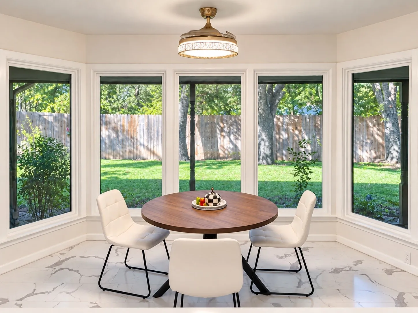 Bay window dining area with a flush-mount light fixture, white trim, and light-toned flooring