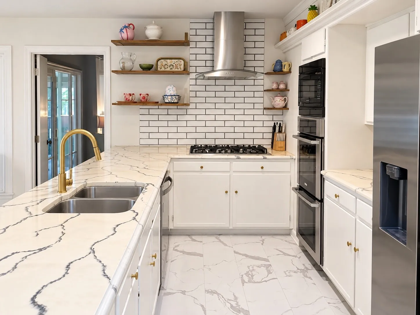 Contemporary kitchen featuring stone countertops, white subway tile backsplash, stainless steel appliances, and white cabinetry