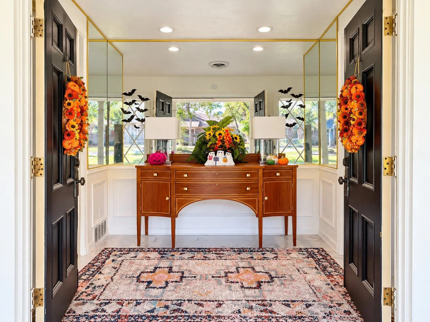 Entryway featuring black paneled doors, wainscoting, recessed lighting, and a console table
