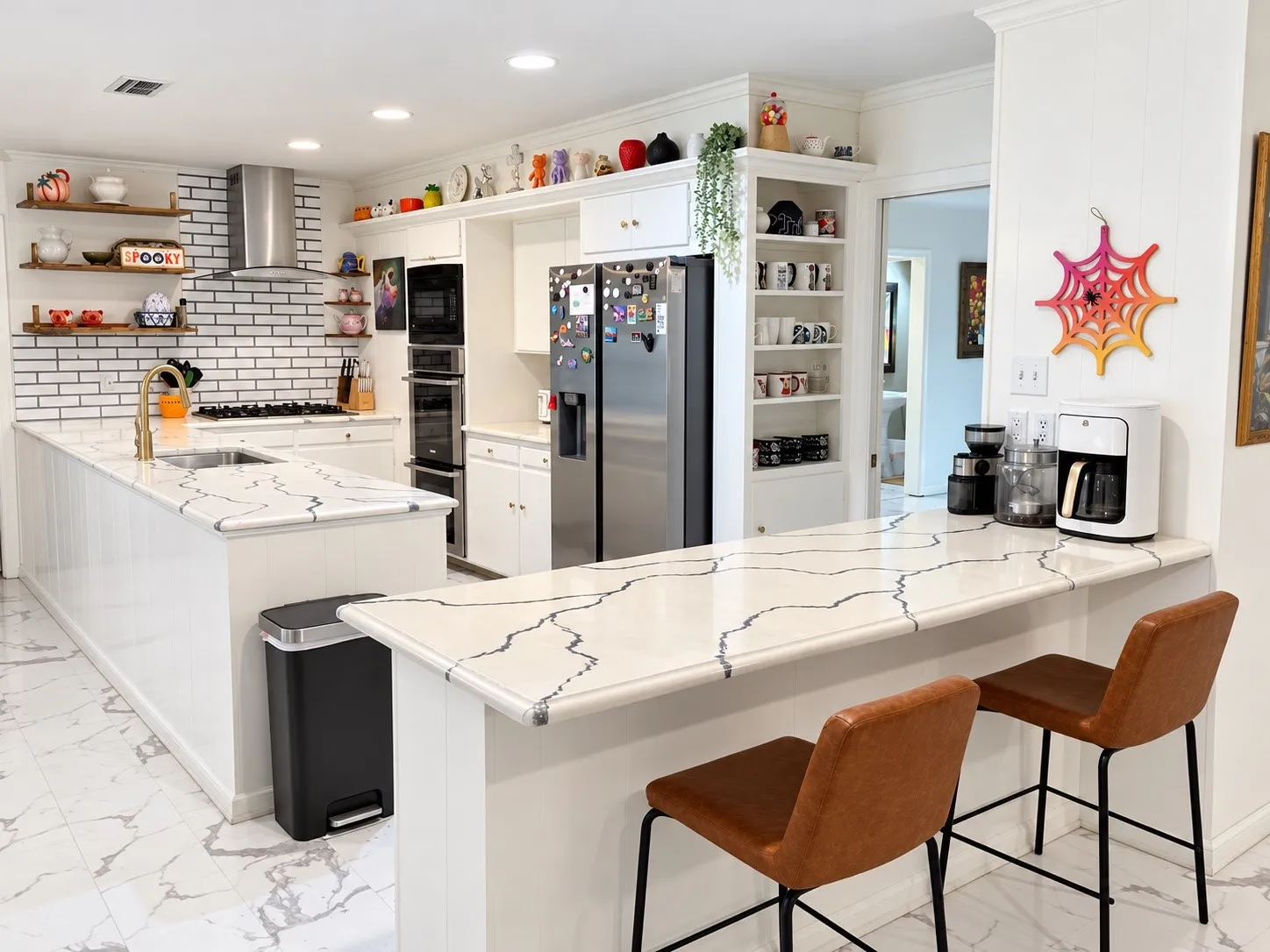 Kitchen featuring white cabinetry, integrated stainless steel appliances, a tile backsplash, and stone-finish countertops