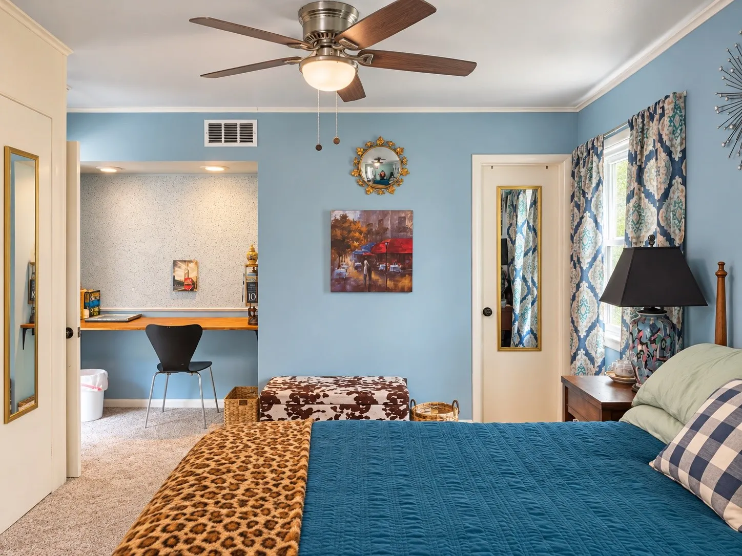 Ceiling fan with integrated lighting, built-in desk, crown molding, and window with patterned drapes