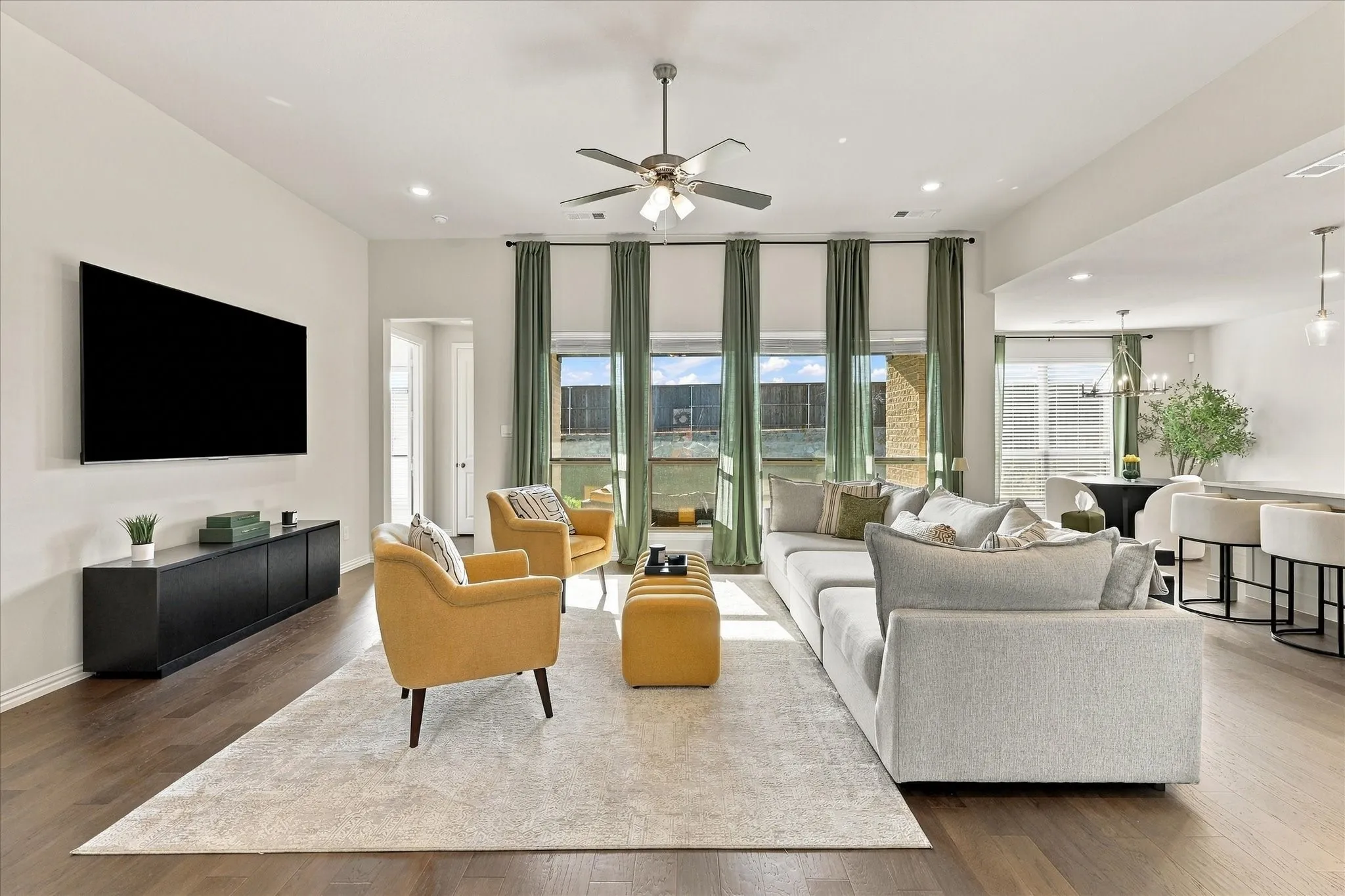 High ceilings, wood-finish flooring, recessed lighting, ceiling fan, and extensive window treatments