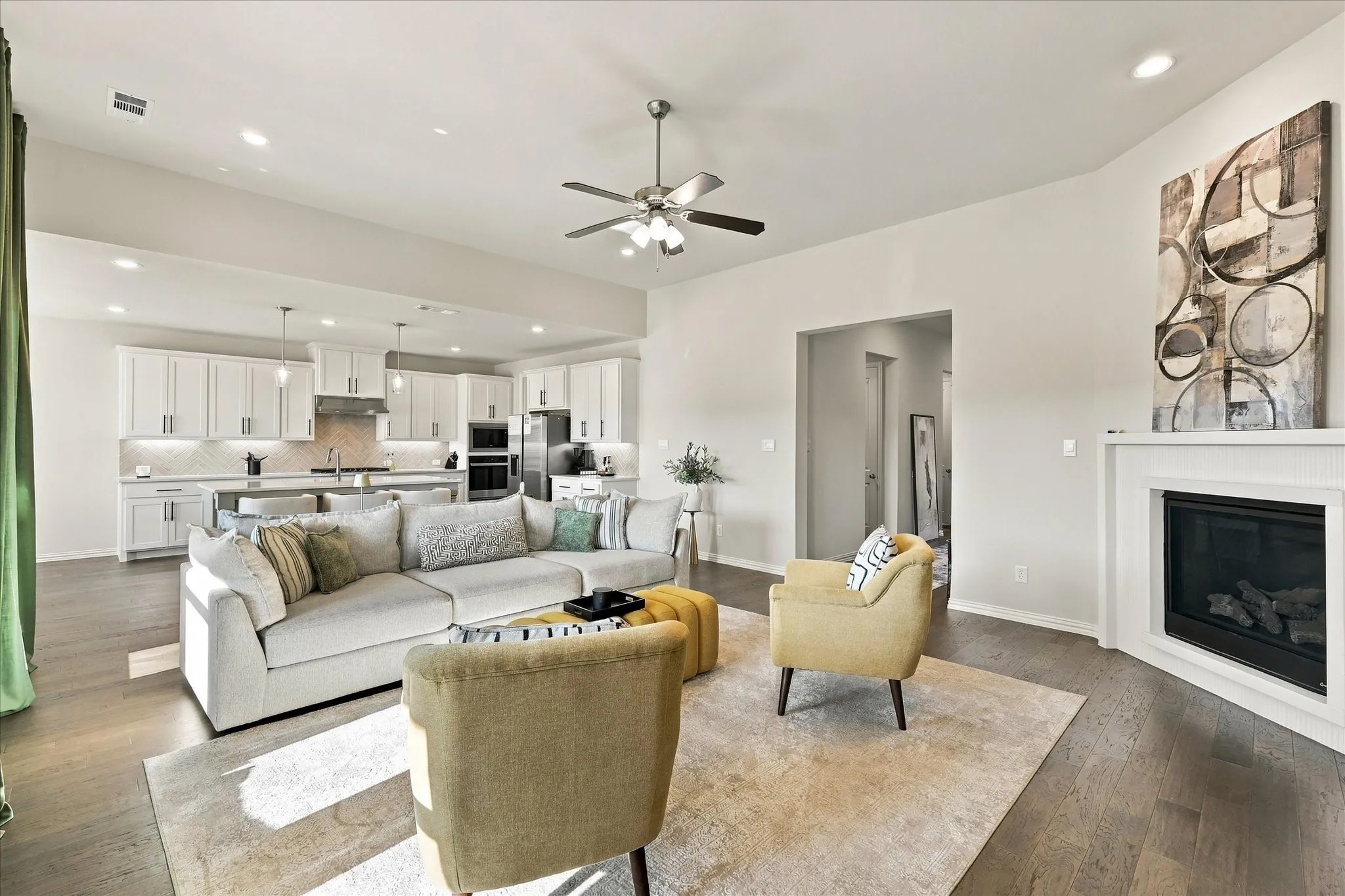 Open concept layout with wood-finish flooring, a contemporary fireplace, recessed lighting, and a ceiling fan