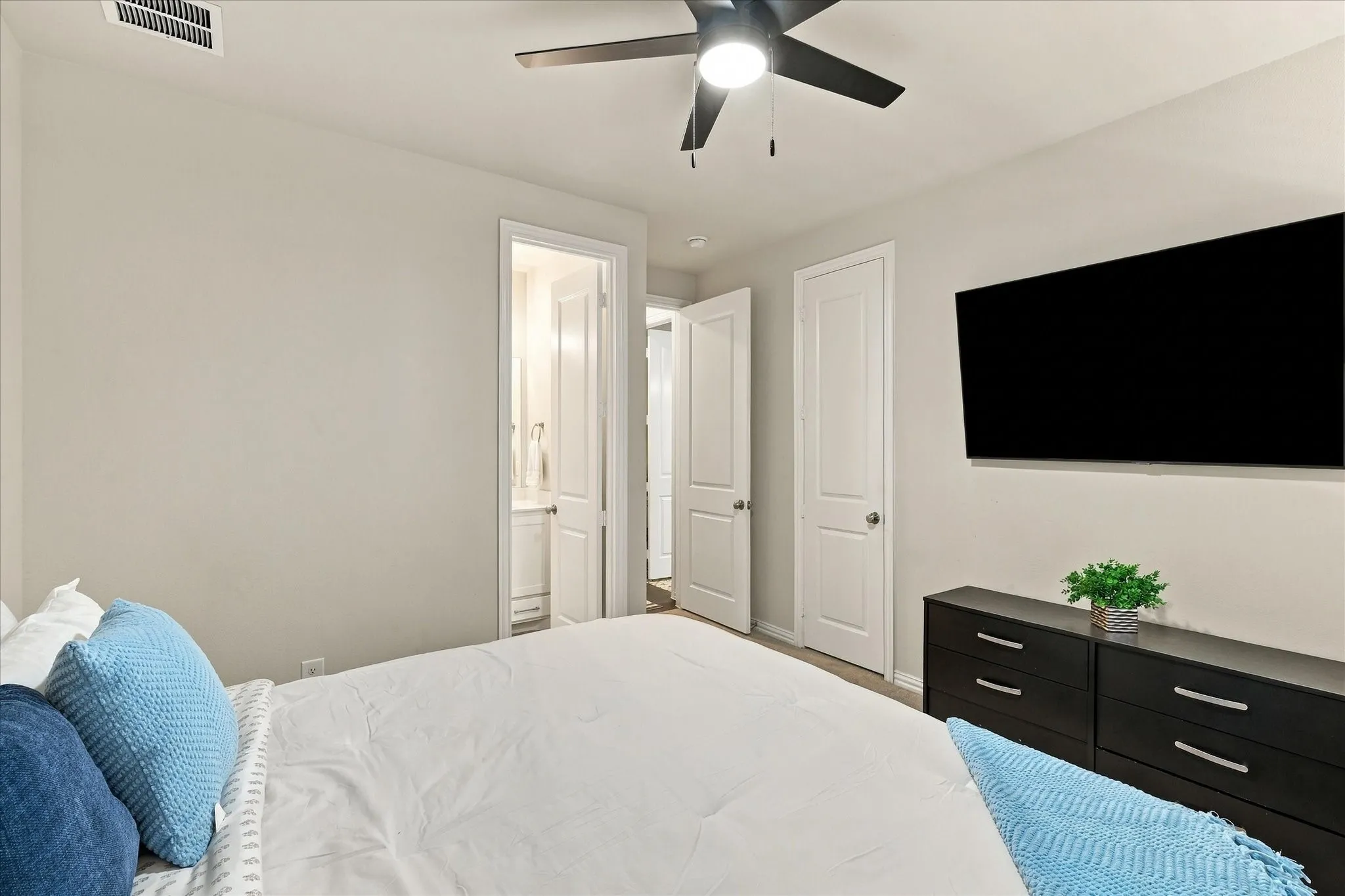 Neutral wall tones, ceiling fan with integrated lighting, and wood-finish flooring