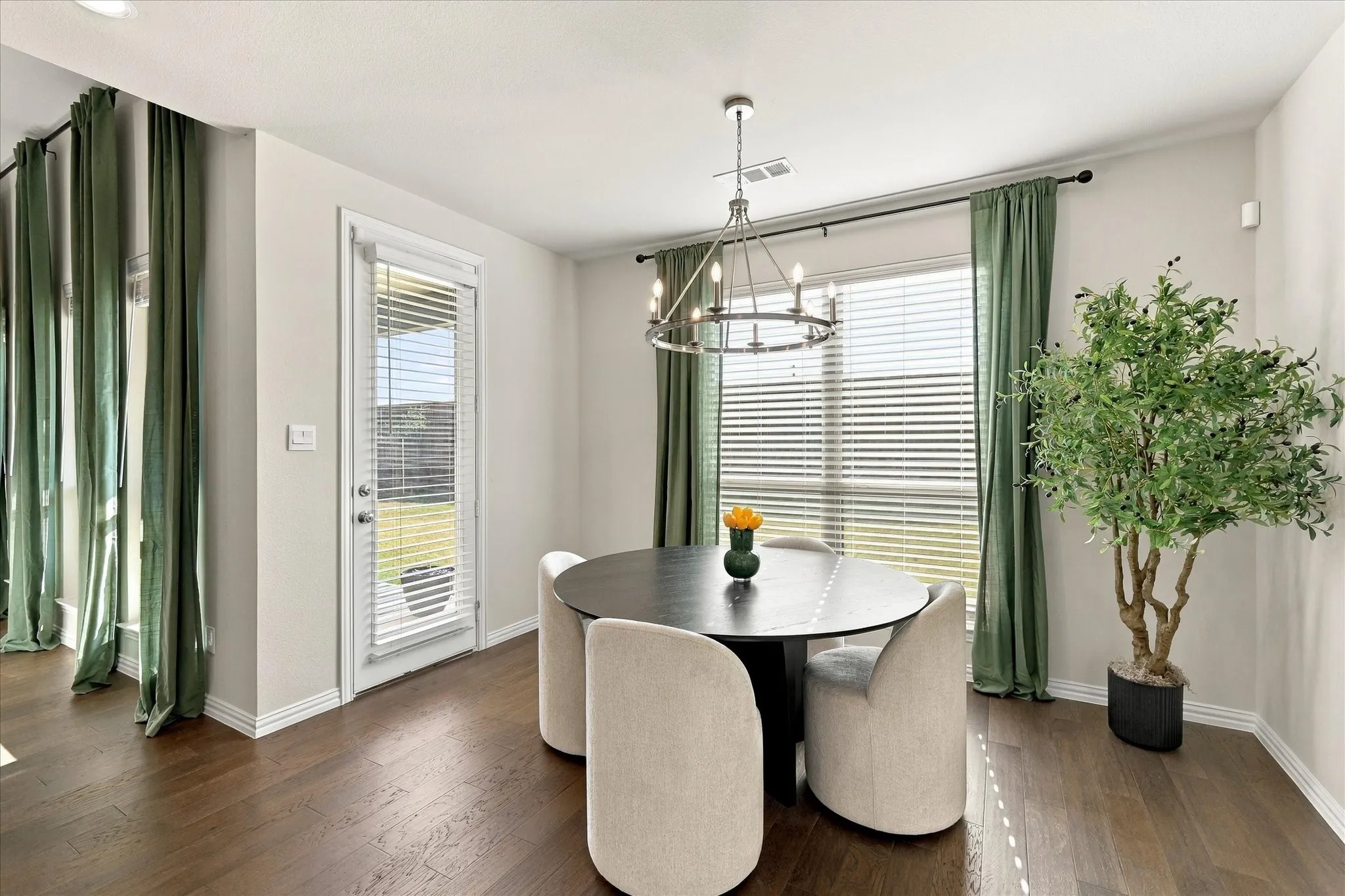 Wood-finish flooring, white baseboards, and a rear exterior door with integrated blinds