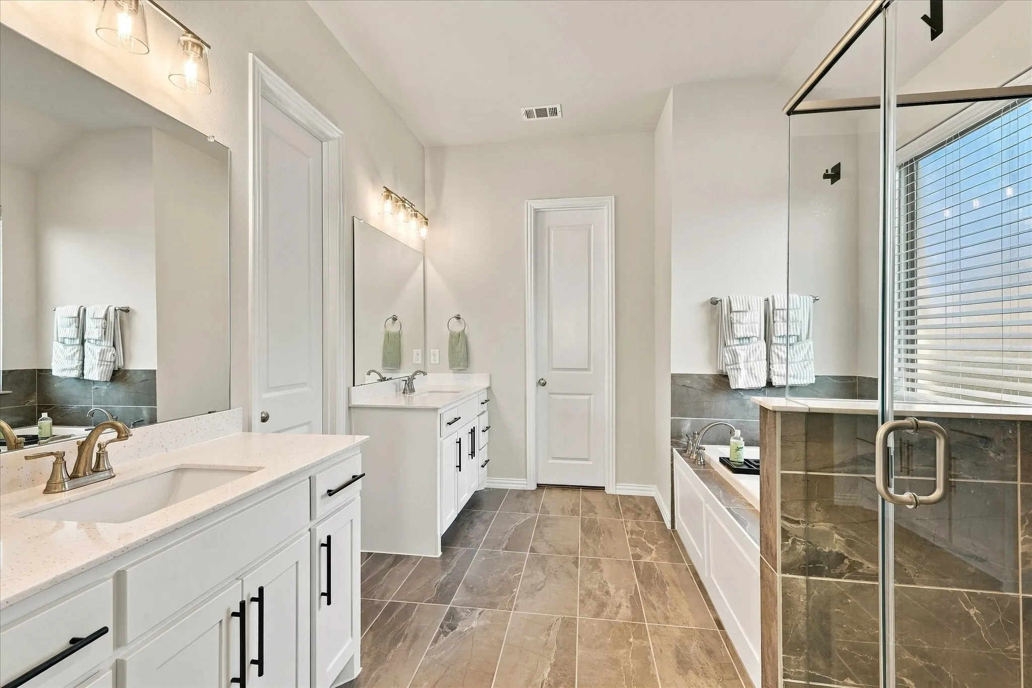 Dual vanities with white cabinetry and quartz countertops