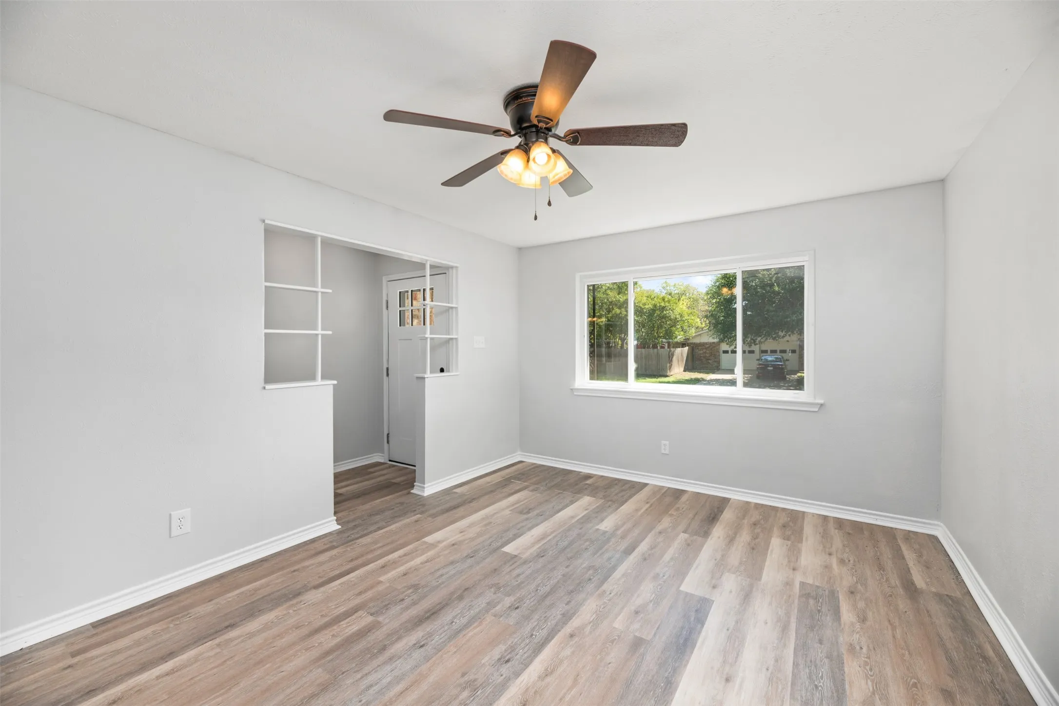 Wood-finish flooring throughout, complemented by a ceiling fan with integrated lighting