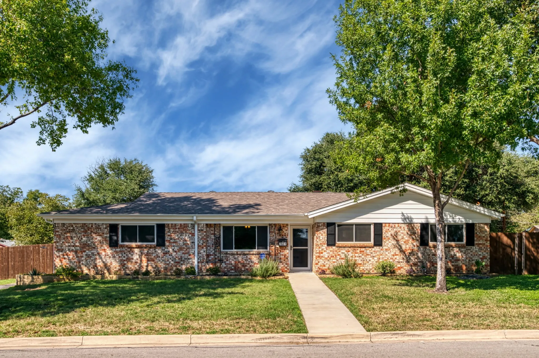 Brick exterior with white siding accents and dark window shutters