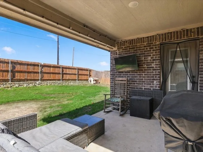 Covered patio with a concrete surface, brick exterior wall, and recessed lighting