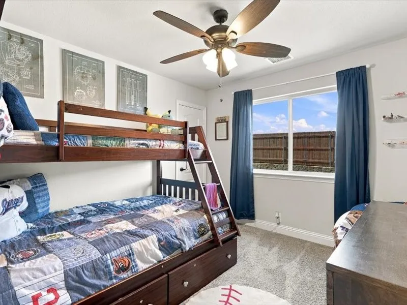 Carpeted flooring, single window with curtains, ceiling fan, and white walls