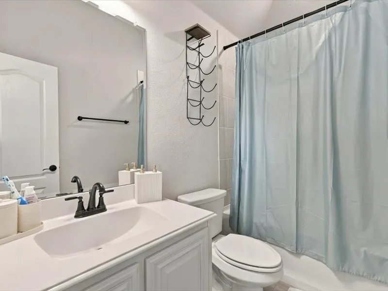 White vanity with panel detailing, integrated sink, and dark bronze-finish faucet