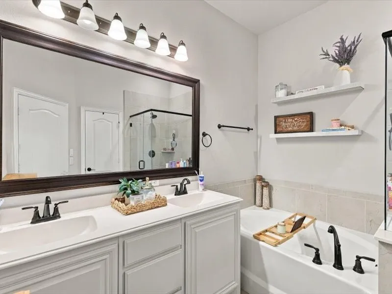 Dual vanity with white cabinetry, white countertops, and matte black fixtures