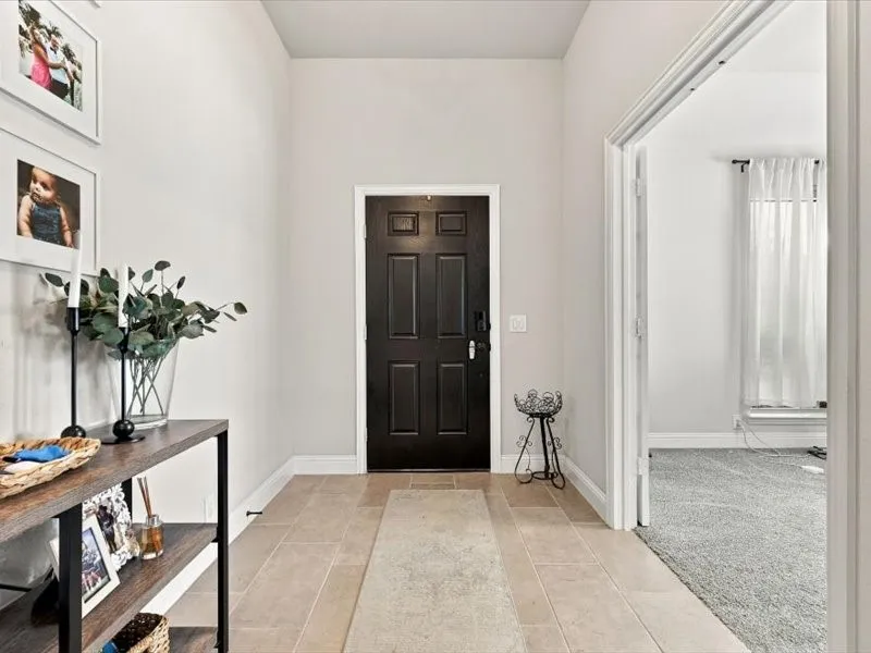 Entryway featuring neutral wall tones, a paneled front door, and tiled flooring