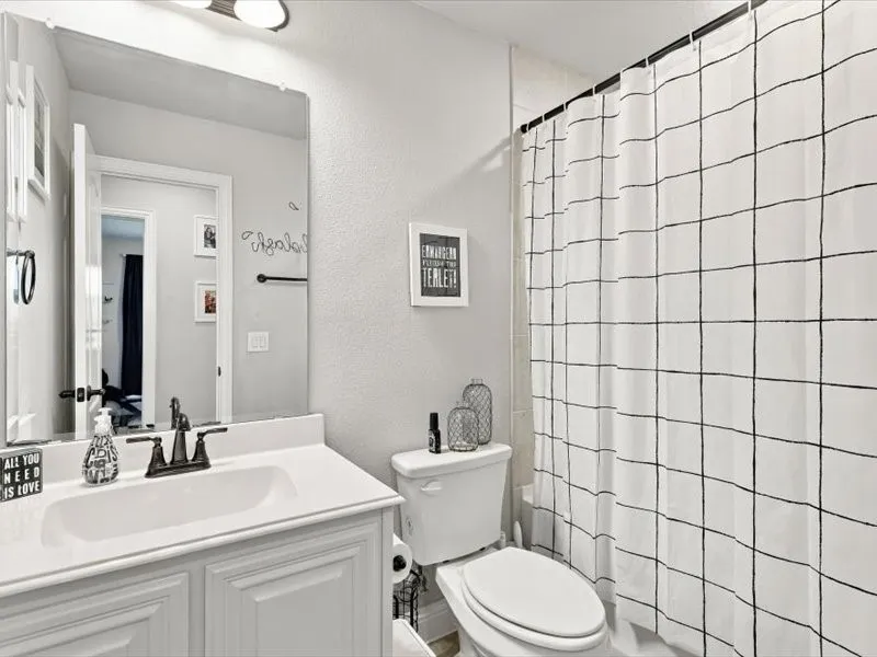 White vanity with shaker-style cabinetry, an integrated sink, and a dark bronze finish faucet